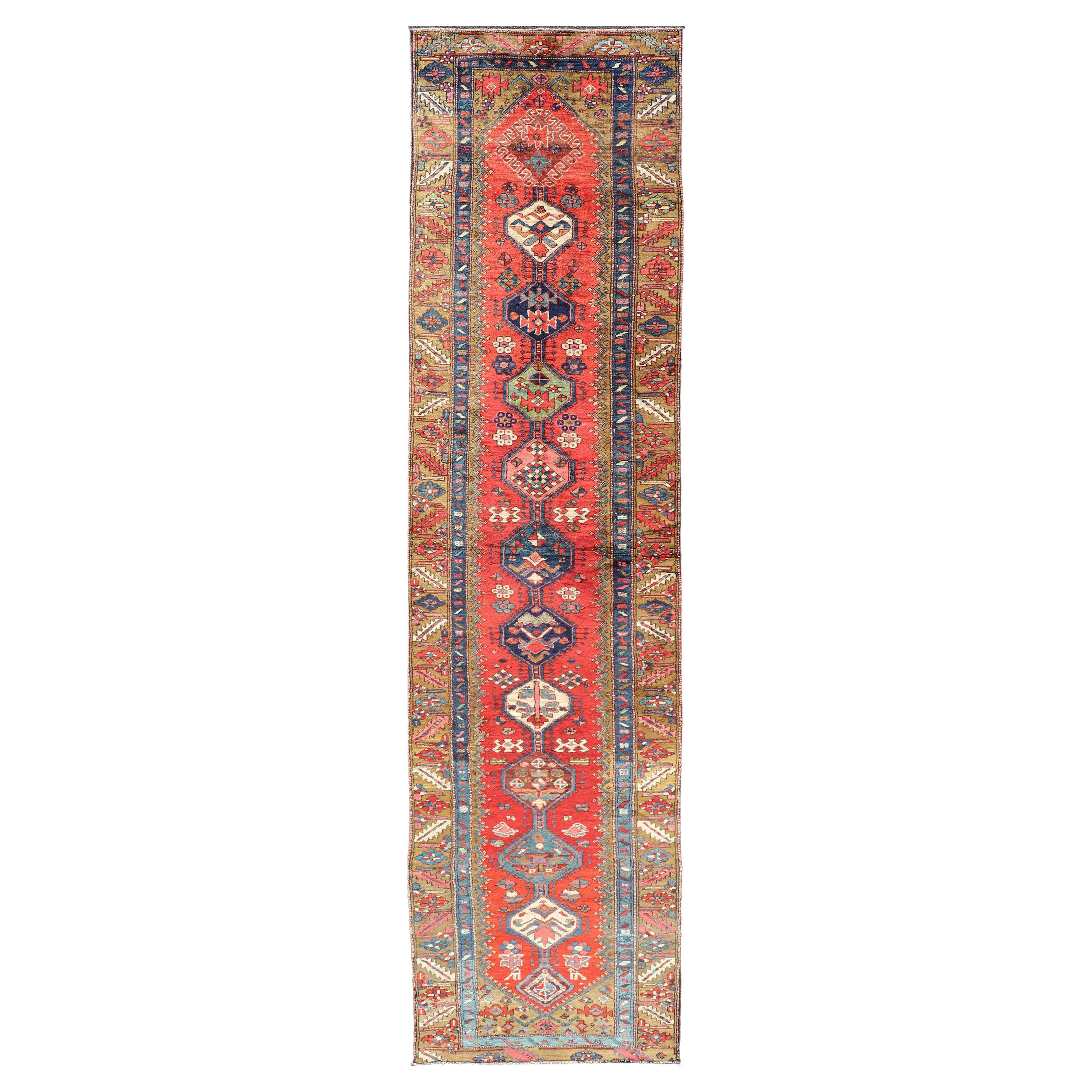 Tapis de couloir persan Heriz ancien dans les tons rouges, bleus, roses, ivoires et terreux