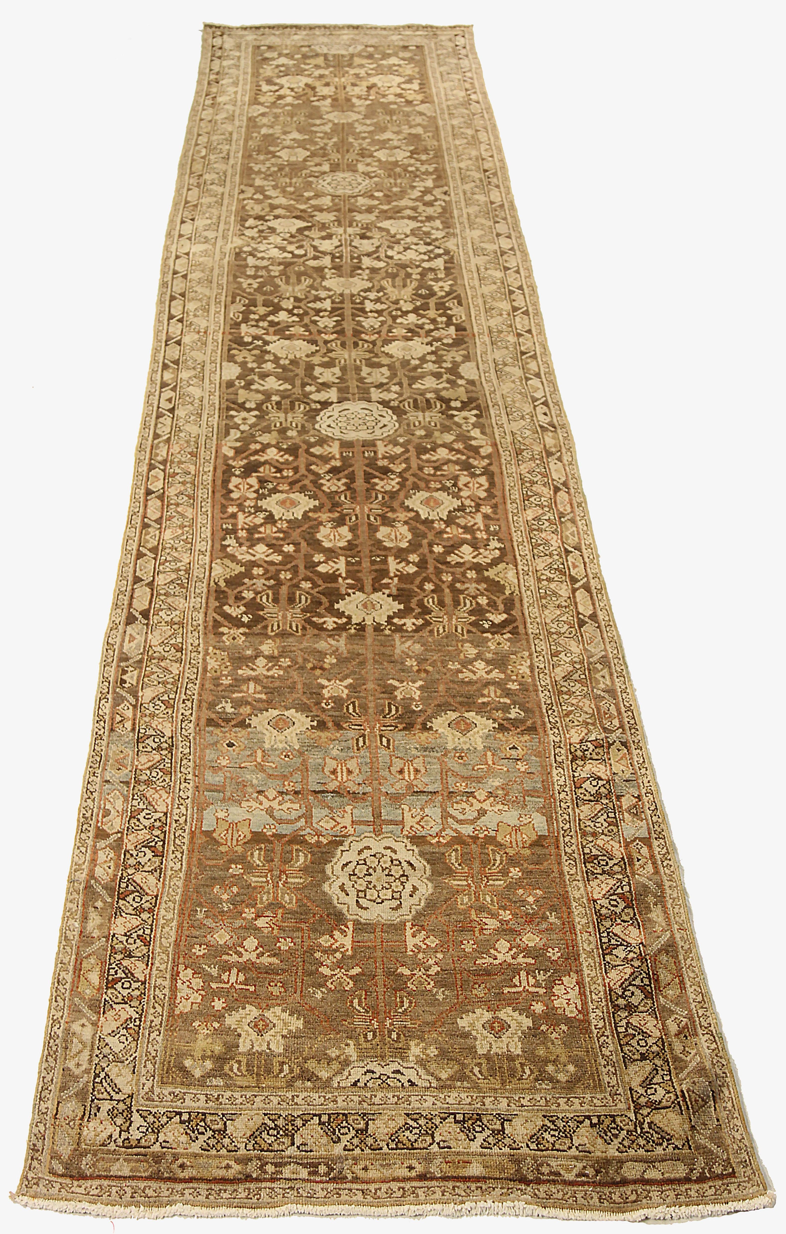 Antique Persian runner rug handwoven from the finest sheep’s wool and colored with all-natural vegetable dyes that are safe for humans and pets. It’s a traditional Heriz design featuring a lovely brown field covered with ivory floral and tribal