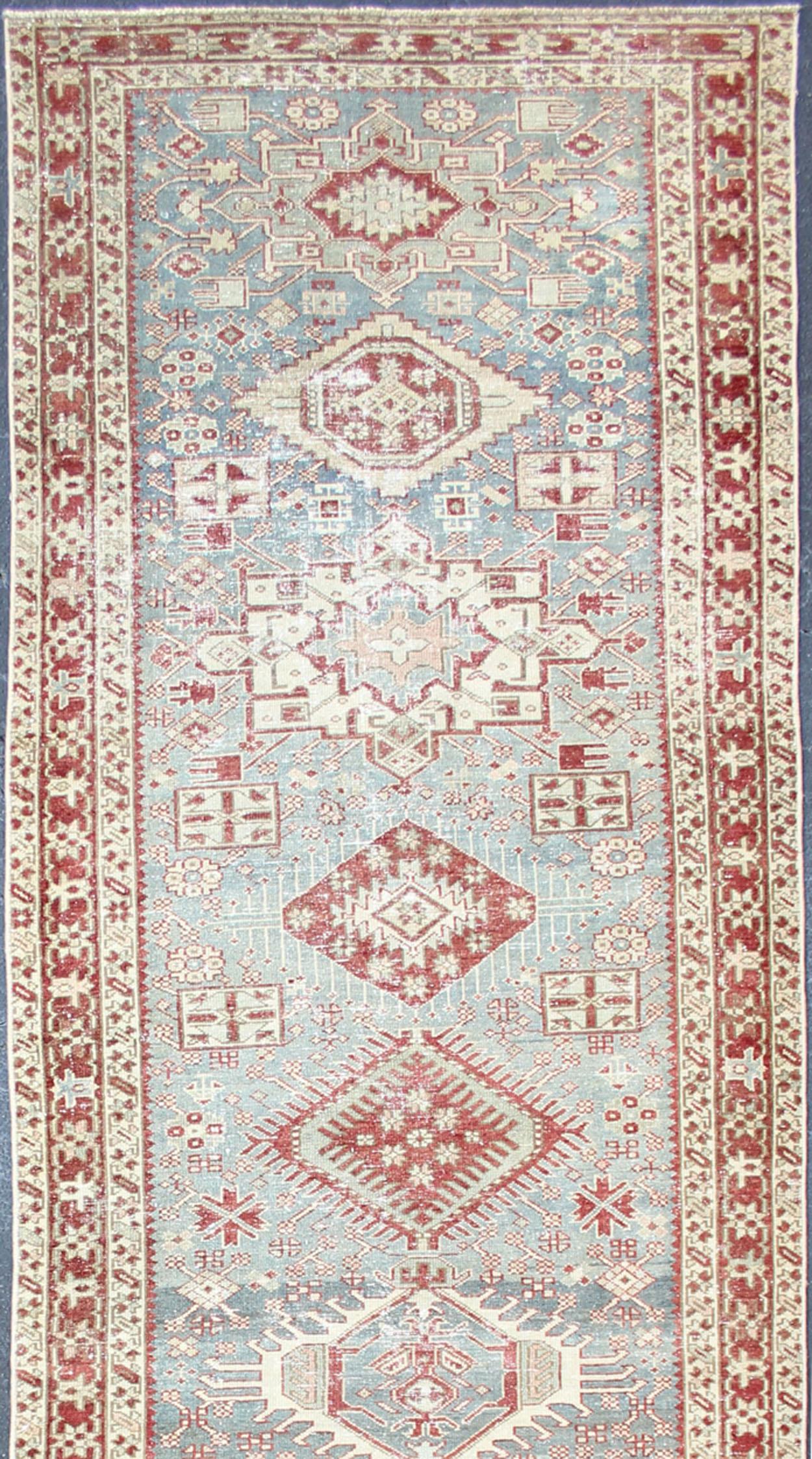 Persian distressed antique Heriz runner with geometric Medallion design in colorful tones including light blue, red, light green rust and brown, rug KBE-200202, country of origin / type: Iran / Heriz, circa 1920

Measures: 3'7 x 13'5

This