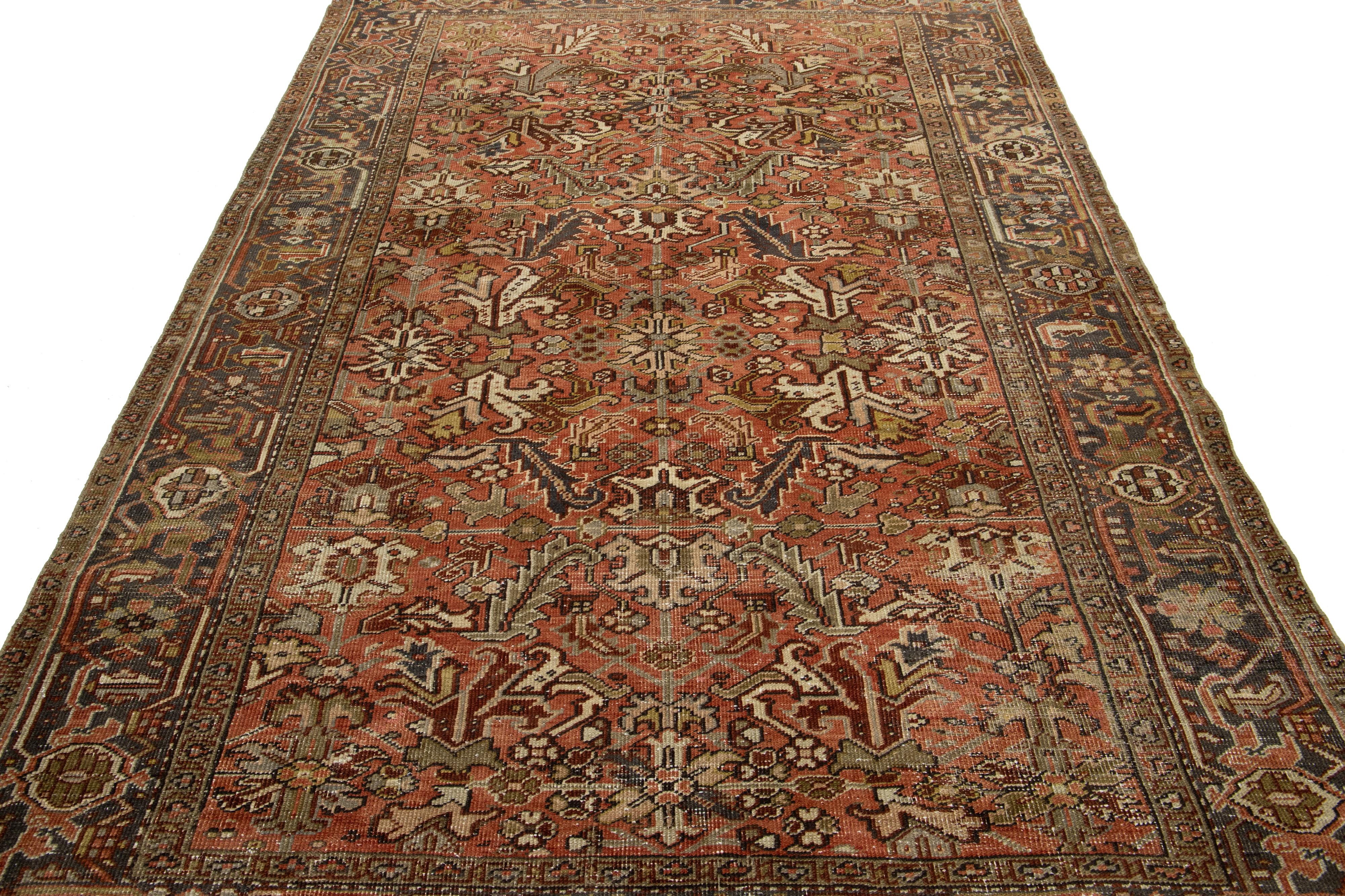 Découvrez le charme exquis de ce tapis ancien en laine Perse Heriz. Son captivant design multicolore all-over apporte de l'éclat à un fond rouille riche et profond, mettant en valeur n'importe quel espace grâce à son caractère unique.

Ce tapis