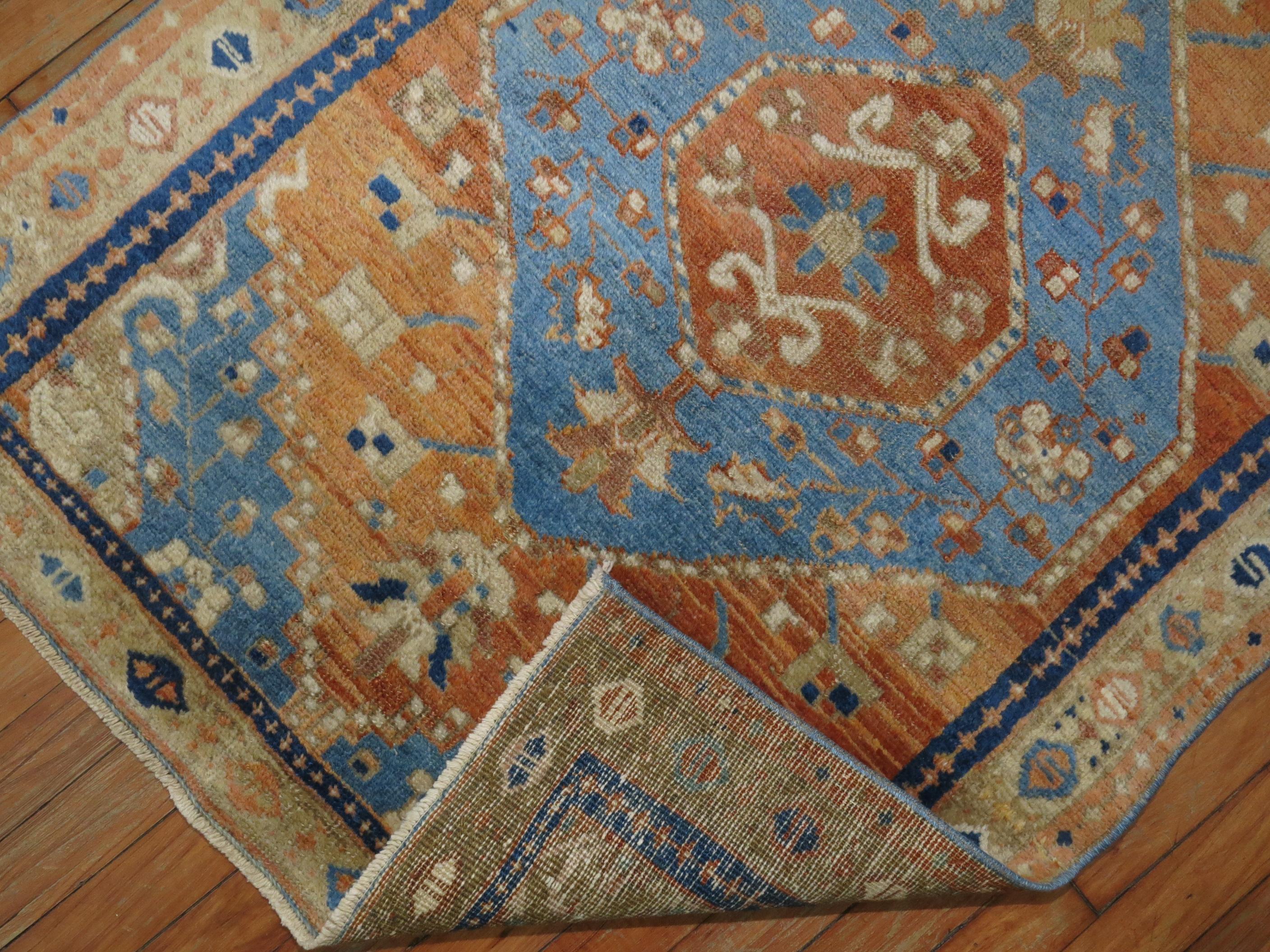 Colorful antique Persian Heriz rug featuring accents in orange and sky blue.