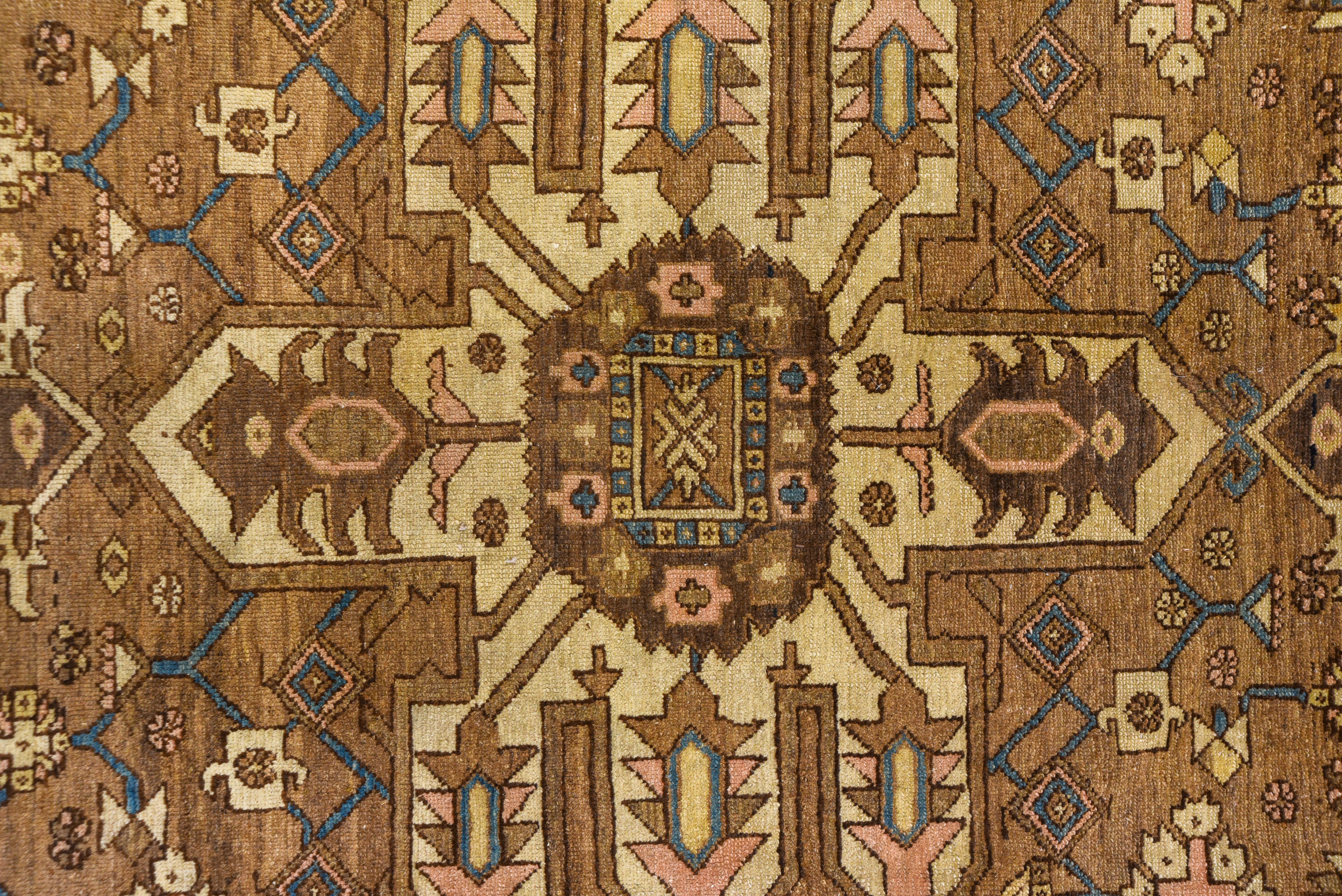This carpet has a light brownish field centered by an ivory octofoil medallion with pendant chains. The tonally end suite border of this good condition NW Persian rustic carpet has a skeletal turtle palmette design. The Serapi Heriz grade stands at