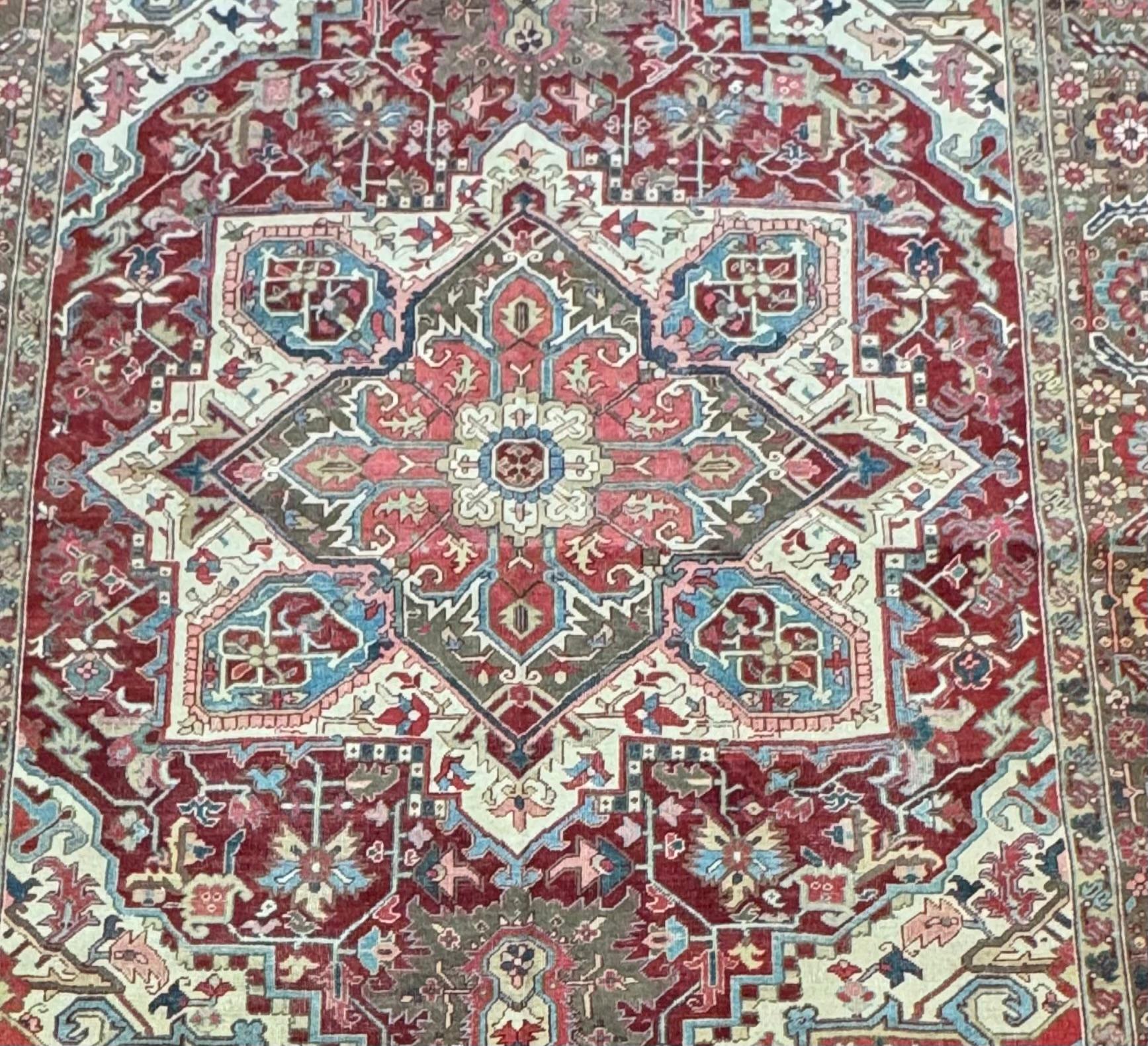 Cet exquis tapis persan Heriz antique, originaire d'Iran au début des années 1900, est un exemple remarquable de l'artisanat, de l'histoire et de l'art persans. Tissé par des maîtres artisans selon des techniques ancestrales, ce tapis présente un