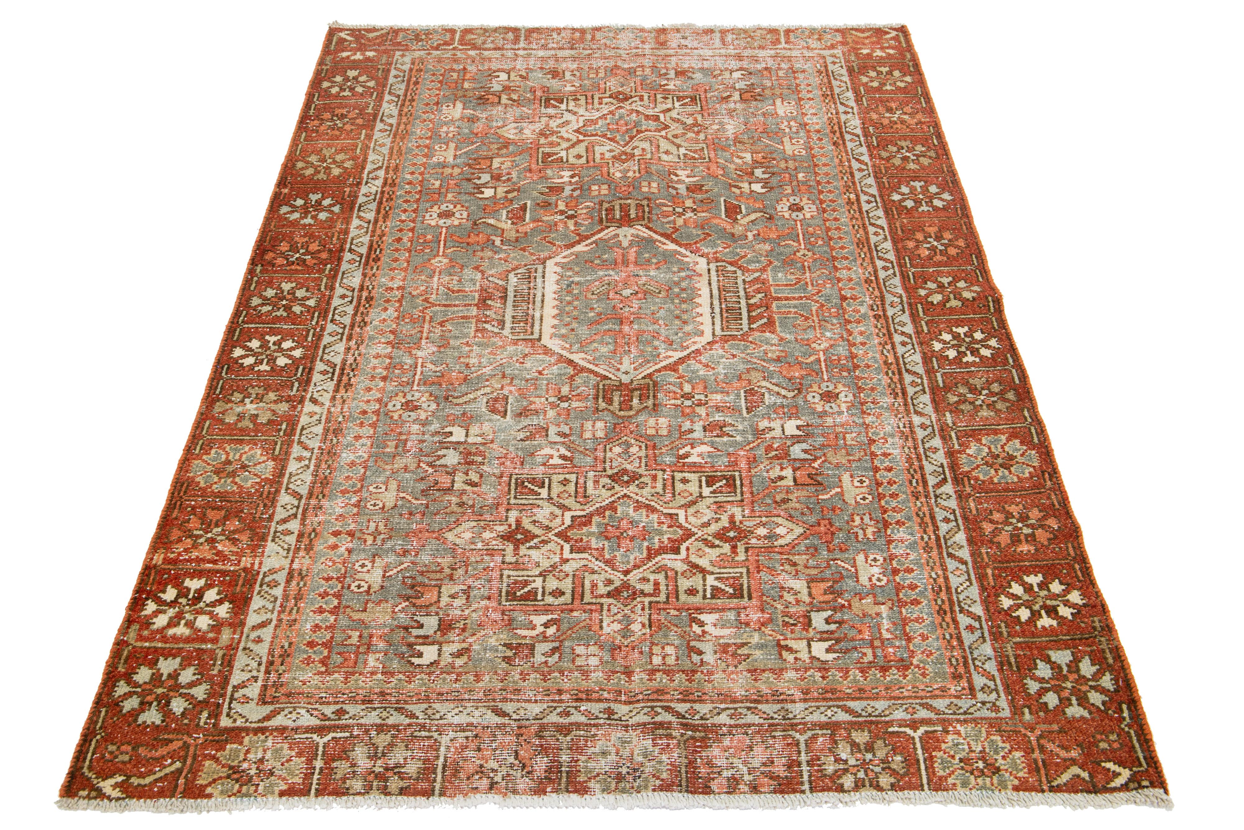 This antique Persian Heriz rug is made with hand-knotted wool. The blue-gray field showcases a captivating tribal pattern with beige and rust shades.

This rug measures 4'4