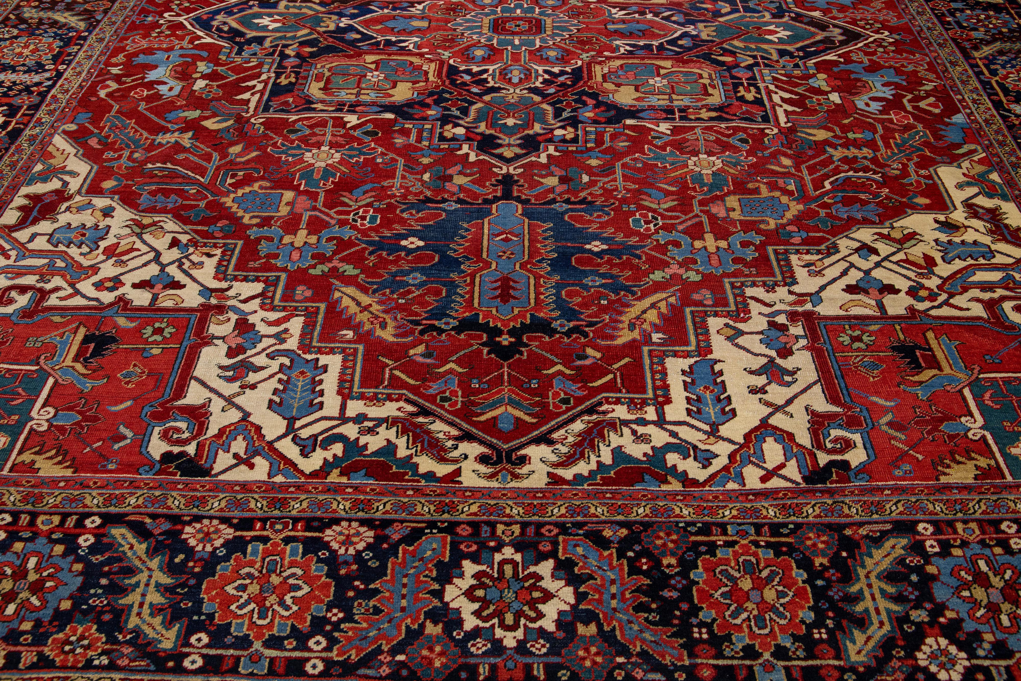 Antique Heriz rug from the 1930s. This unique Persian masterpiece is hand knotted from premium wool, with a red field and multicolor accents making up a Classic medallion pattern. This luxurious and timeless oriental rug will be an eye-catching