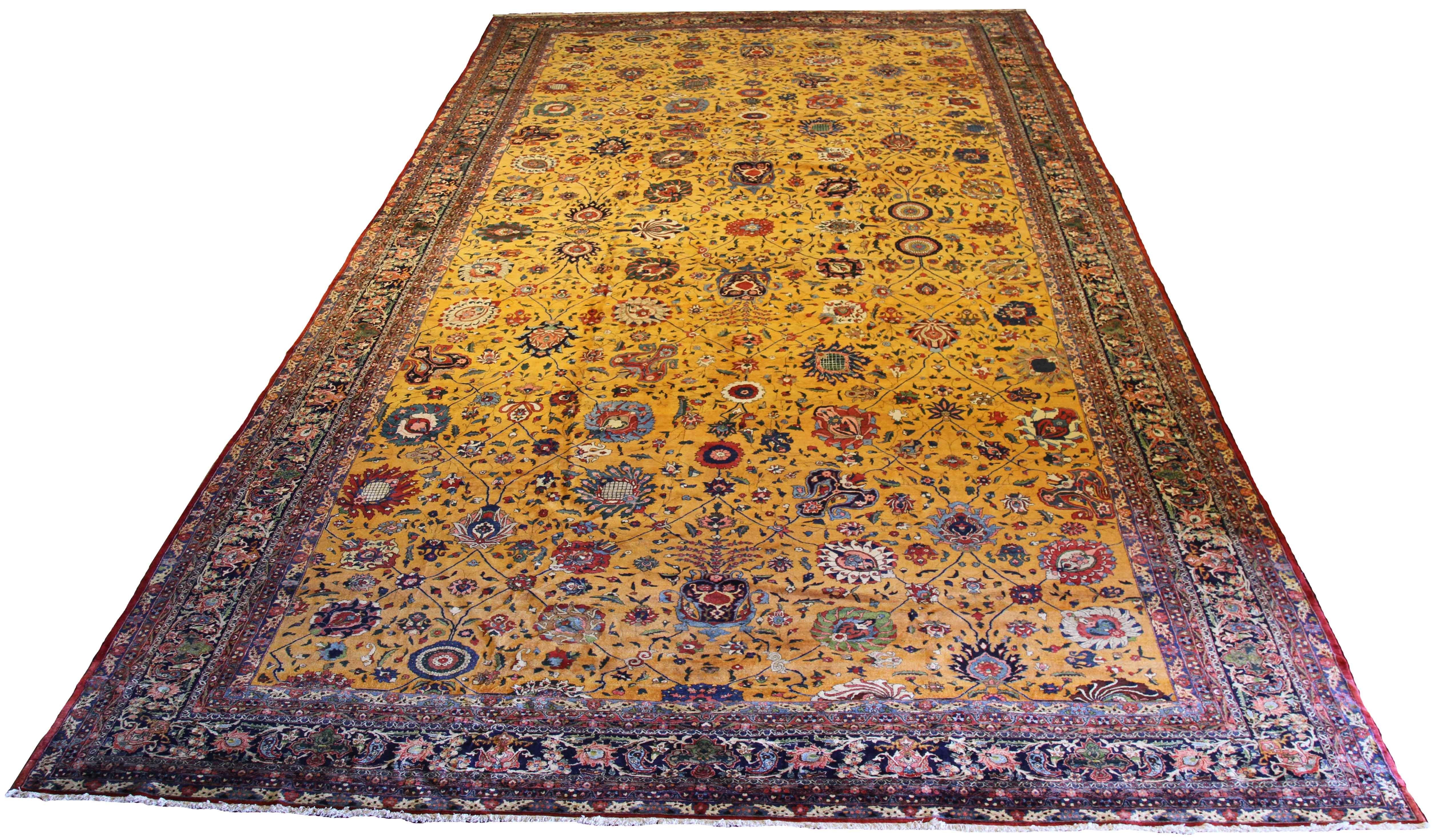 Large antique Persian rug handwoven from the finest sheep’s wool and colored with all-natural vegetable dyes that are safe for humans and pets. It’s a traditional Isfahan Masterpiece design featuring colored floral details on a golden field. It's a
