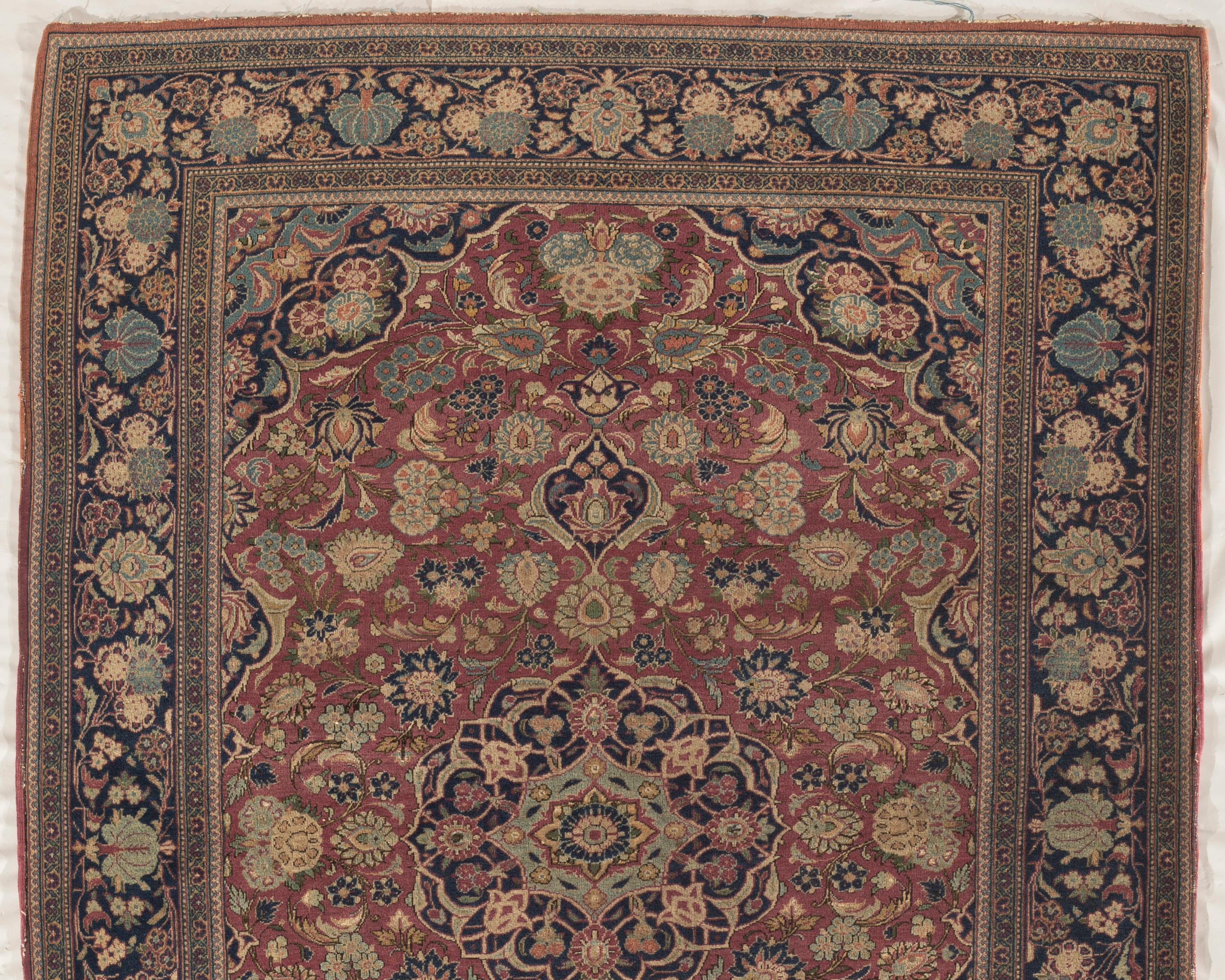 Antique Persian Isphahan rug, circa 1900. A lovely handwoven Persian Isphahan rug renowned for their superb artistry, craftsmanship, and excellent material, the rug has a medallion at the center on a red ground and stylized allover flower and vinery
