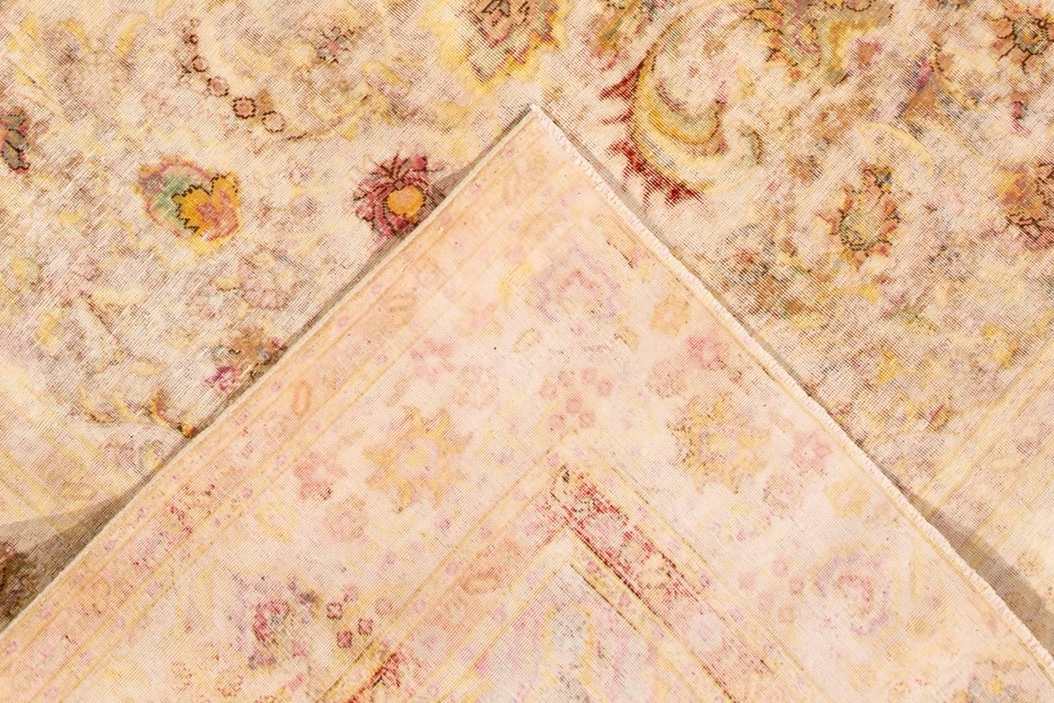 A hand-knotted Kerman rug with all-over design on a ivory field. This rug measures 9'5