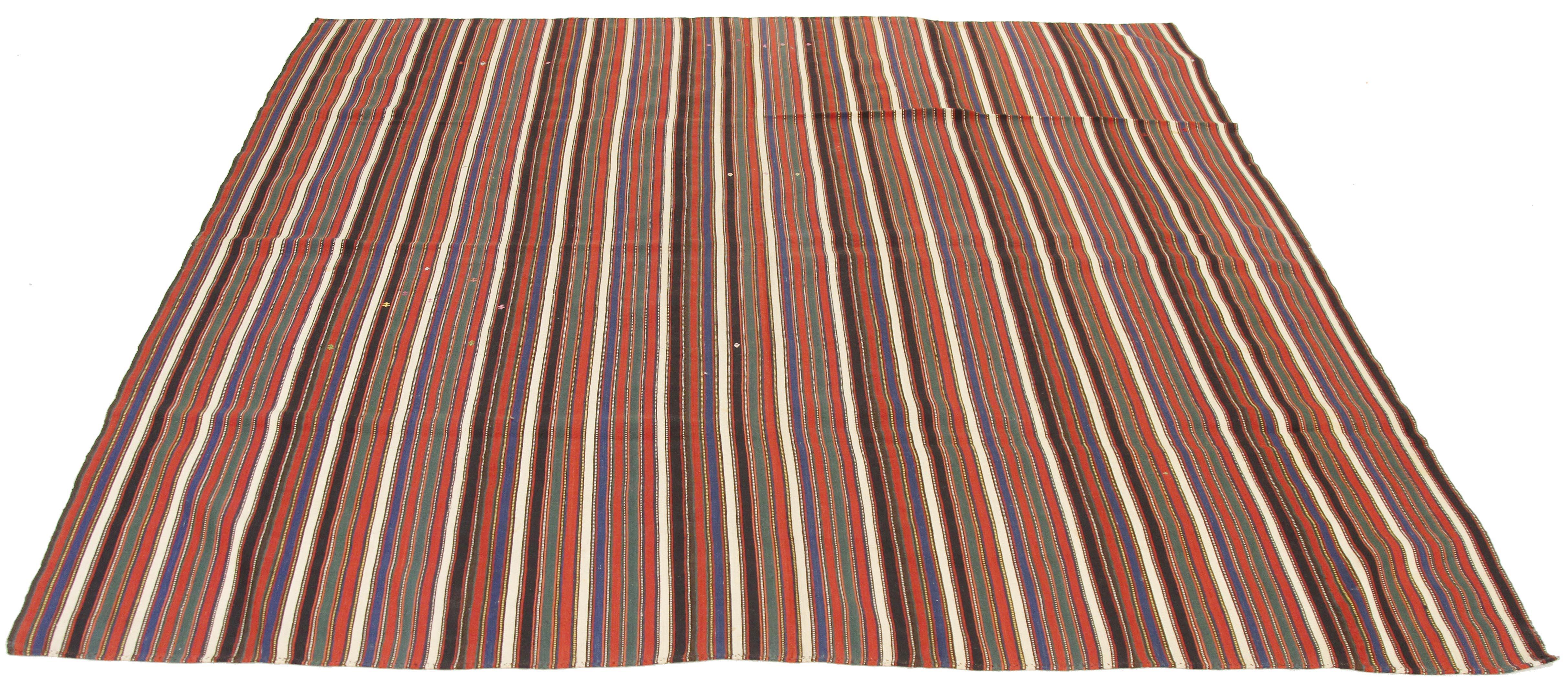 Antique Persian rug handwoven from the finest sheep’s wool and colored with all-natural vegetable dyes that are safe for humans and pets. It’s a traditional Jajim flat-weave design featuring a red, green, and blue striped field. It’s a stunning