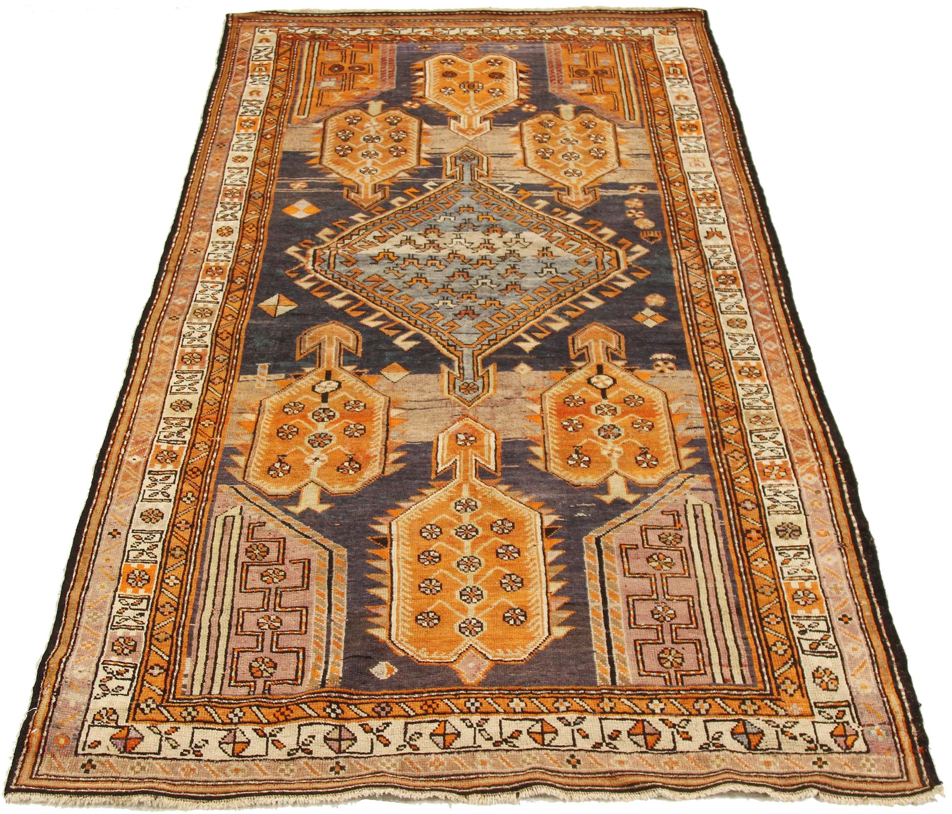 Antique Persian runner rug from the 20th century handwoven from the finest sheep’s wool and colored with all-natural vegetable dyes that are safe for humans and pets. It’s a traditional Karabagh design featuring a blend of orange and navy tribal