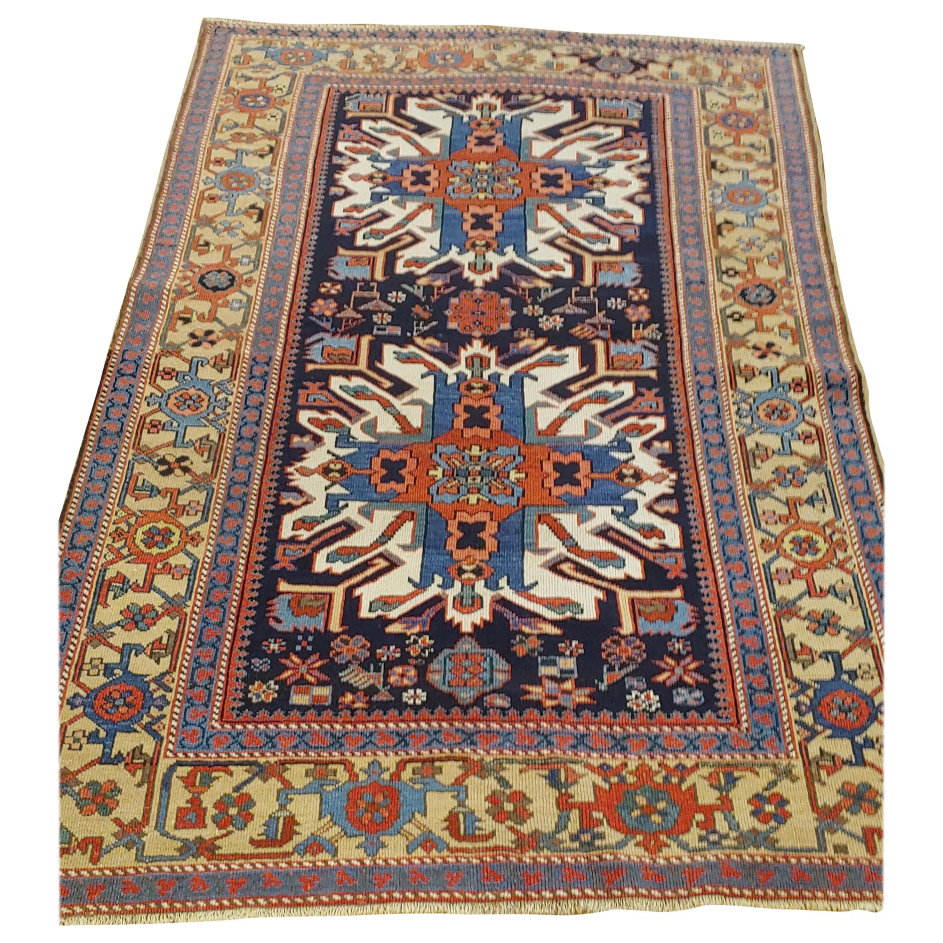 This beautiful navy blue Persian Karaja is dated 1910. Karaja is a village just outside Heriz and is sometimes called a Heriz. This piece has an unusual Eagle Kazak motif along with a surprising camel colored background border. It is 4-7 x 6-9. A