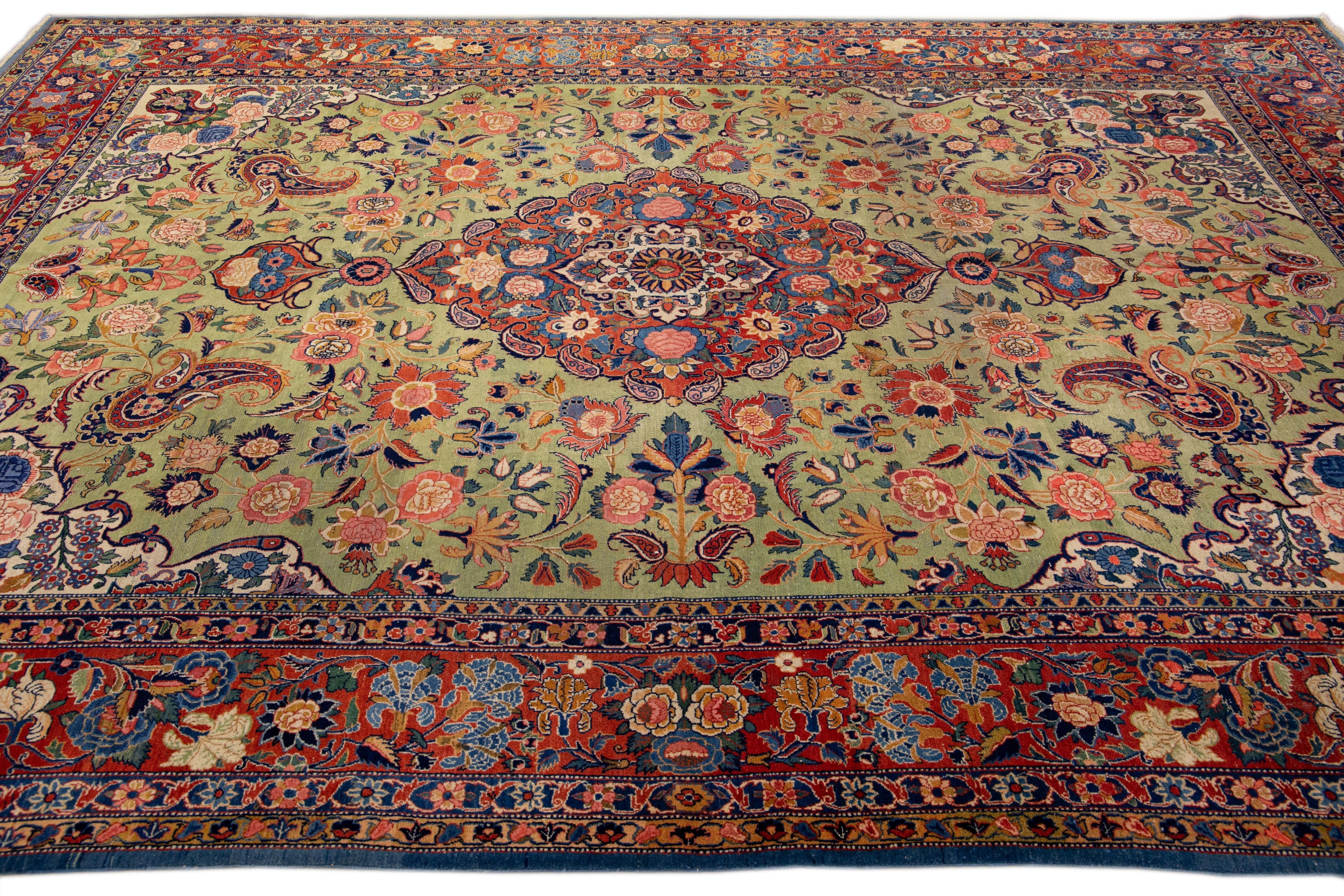 This Persian rug is made of wool and is hand-knotted in the antique Kashan. The green field is complemented by a beautiful all-over medallion floral design with multicolor accents. The rusted frame adds to the rug's unique character and overall