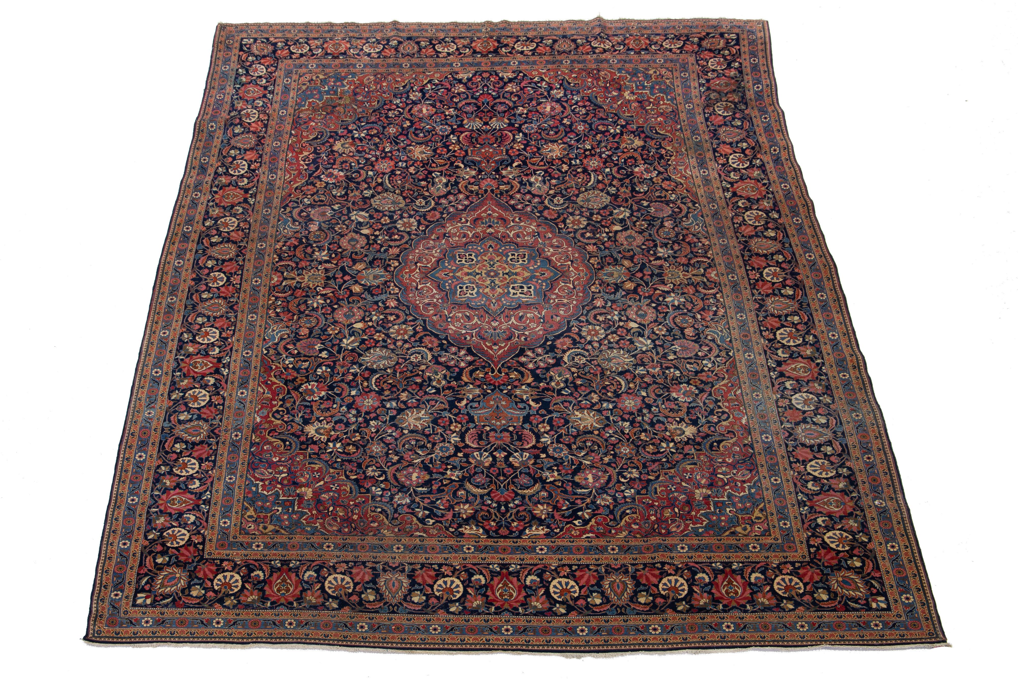 Magnifique Mohtasham antique  Tapis en laine nouée à la main au Kashan, avec un champ bleu marine. Ce tapis persan aux accents rouges et multicolores présente un superbe motif floral en médaillon sur tout le pourtour.

Ce tapis mesure 9' x 12'.
 