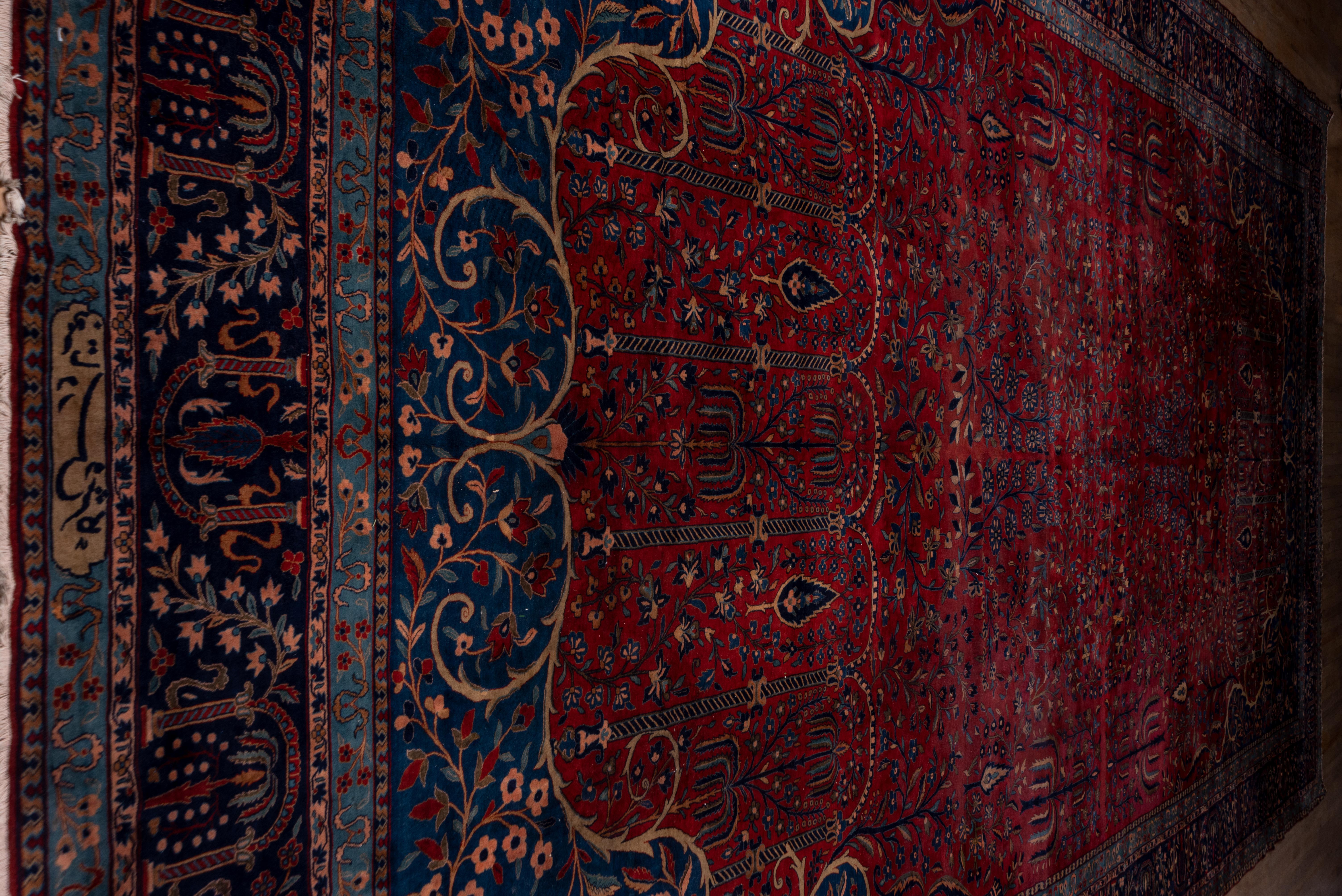 This is an attractive example of the interwar Manchester merino wool Kashan carpets with ruby red fields and a floral pattern influenced by 