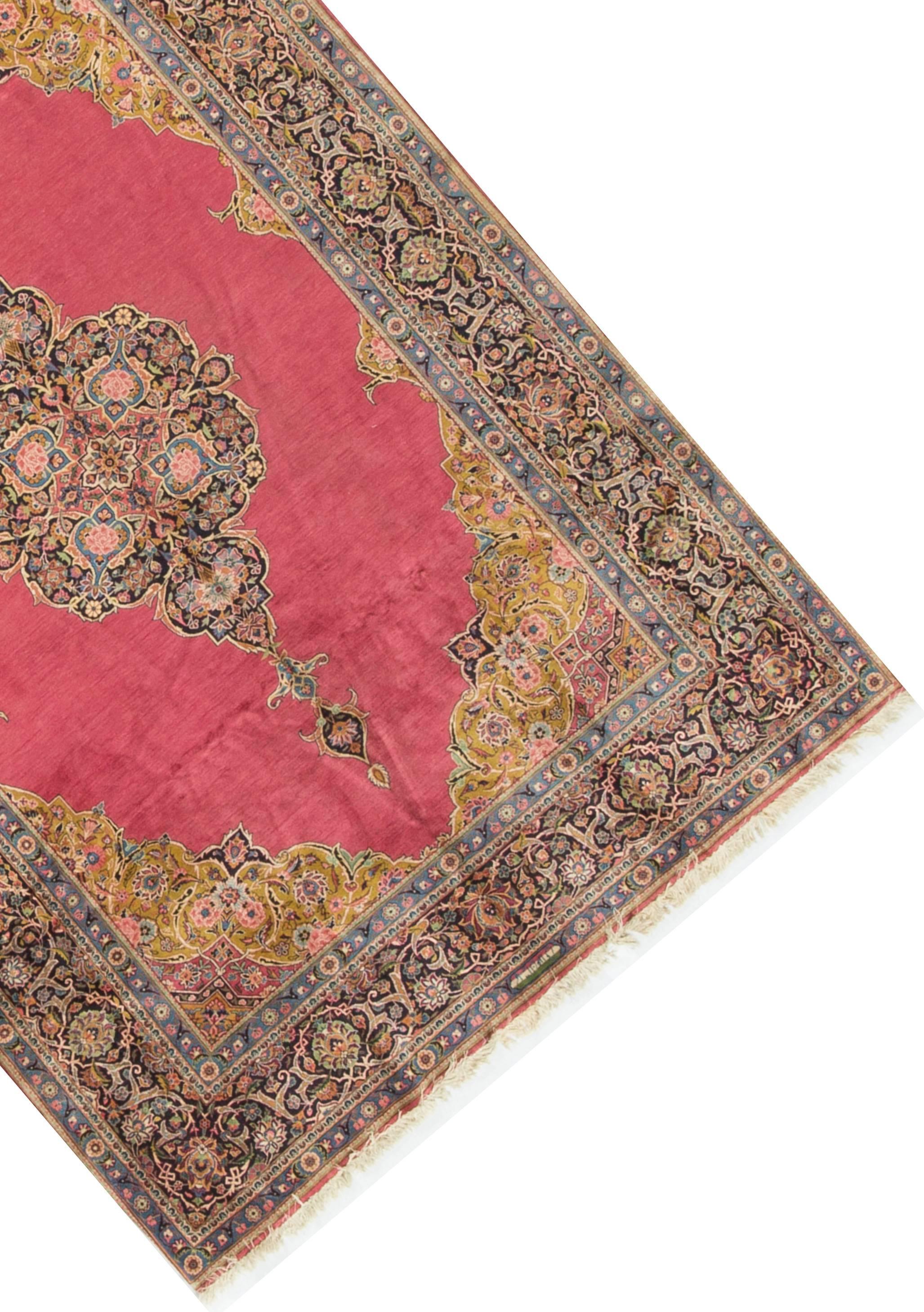 Persian antique Kashan rug, circa 1910. The plain central filled with a wonderful motif repeating the main border design but with six exquisite floral designs enclosed in powder blue vases. The corner spandrels introduce another color that brings a