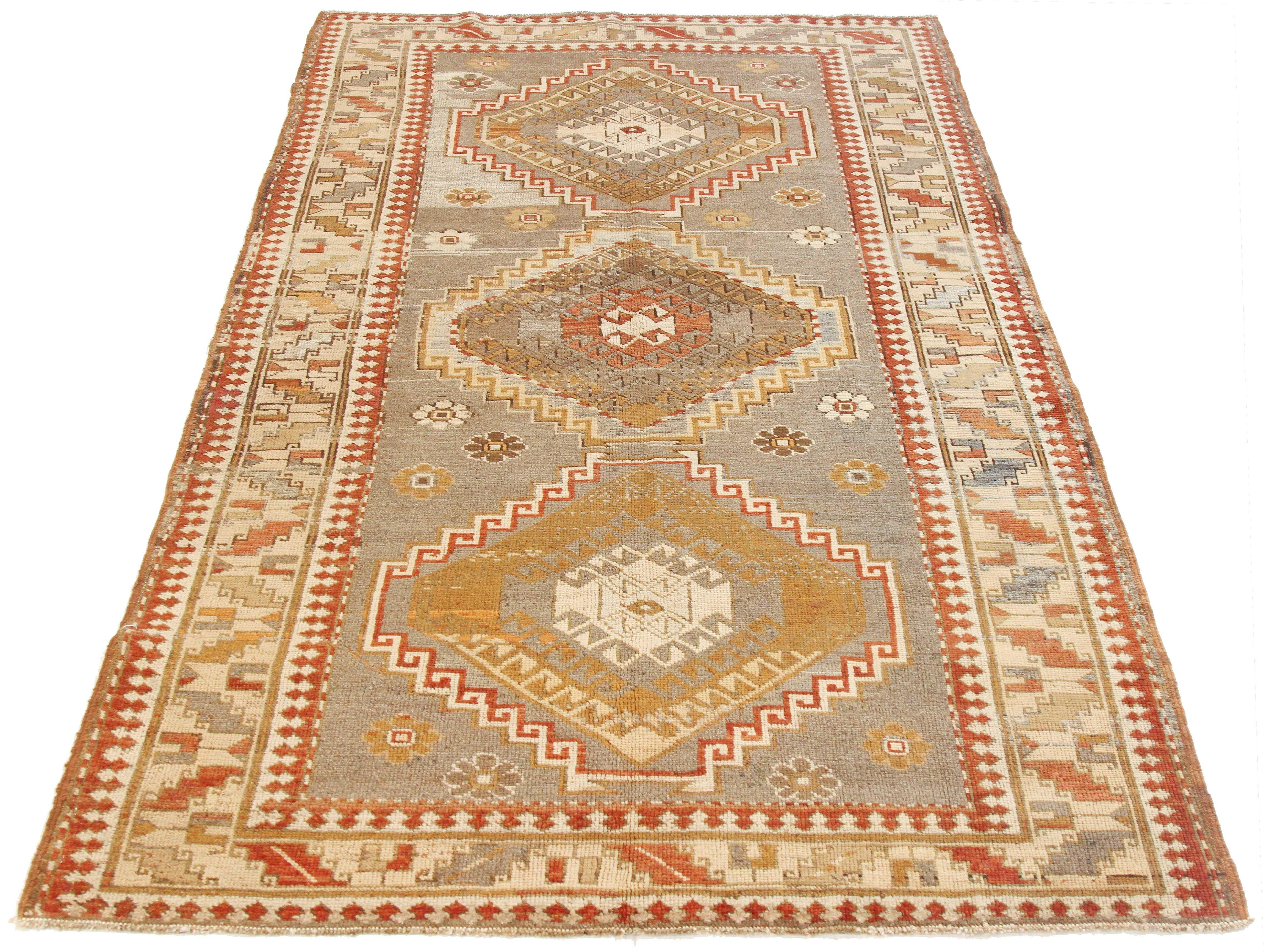 Antique Persian rug handwoven from the finest sheep’s wool and colored with all-natural vegetable dyes that are safe for humans and pets. It’s a traditional Kazak design featuring tribal medallion details in brown and red over an ivory field. It’s a