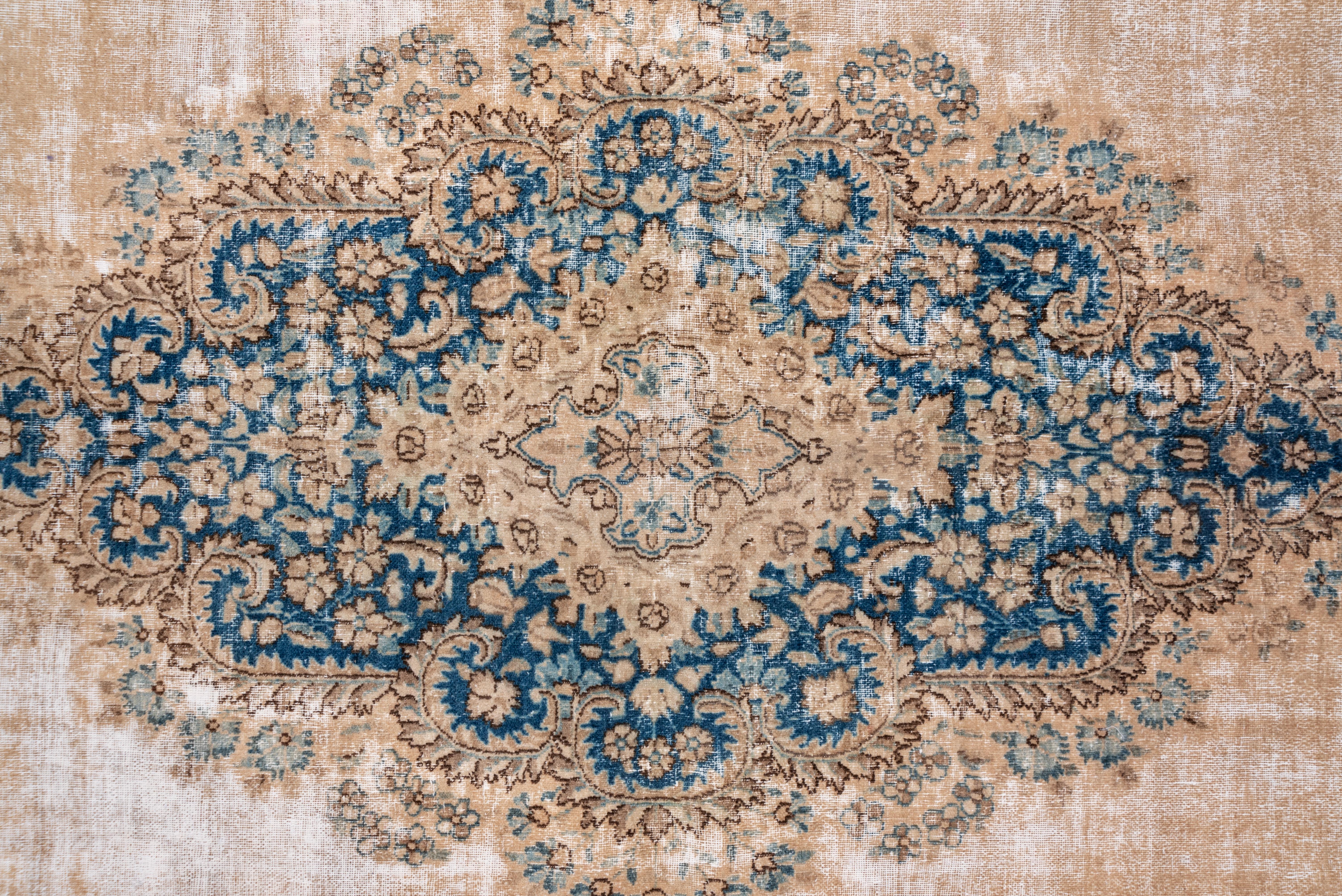 The creamy eggshell open field displays a lobed tall lozenge medallion with developed palmettes. The field is edged by a broad,filigree floral pattern, and the mid-blue broken border features complex palmettes. This SE Persian carpet was made for
