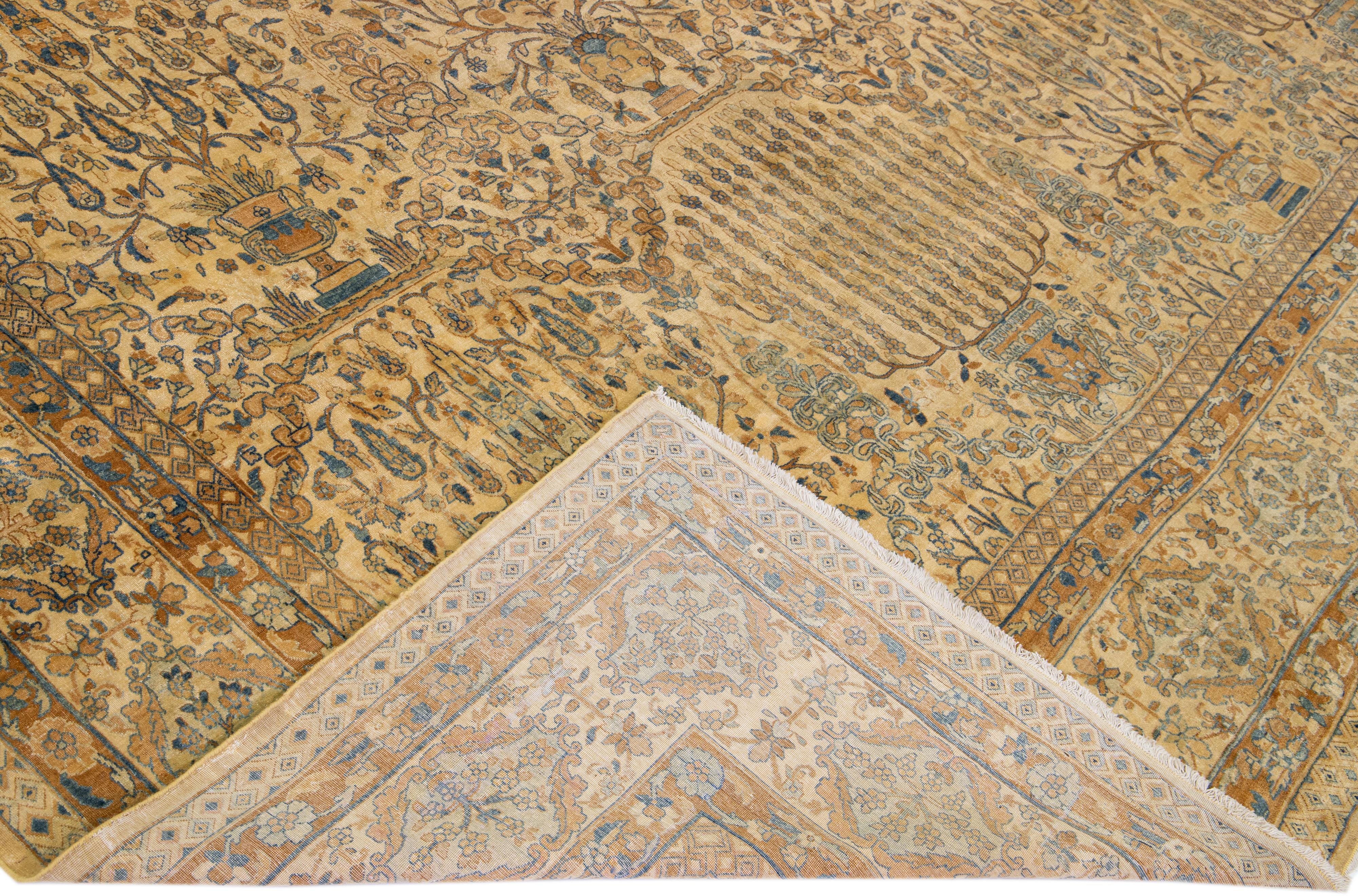 Beautiful antique Kerman hand-knotted rug with a goldenrod field. This Persian rug has blue accents all over the gorgeous Botanical Floral design.

This rug measures 12'2