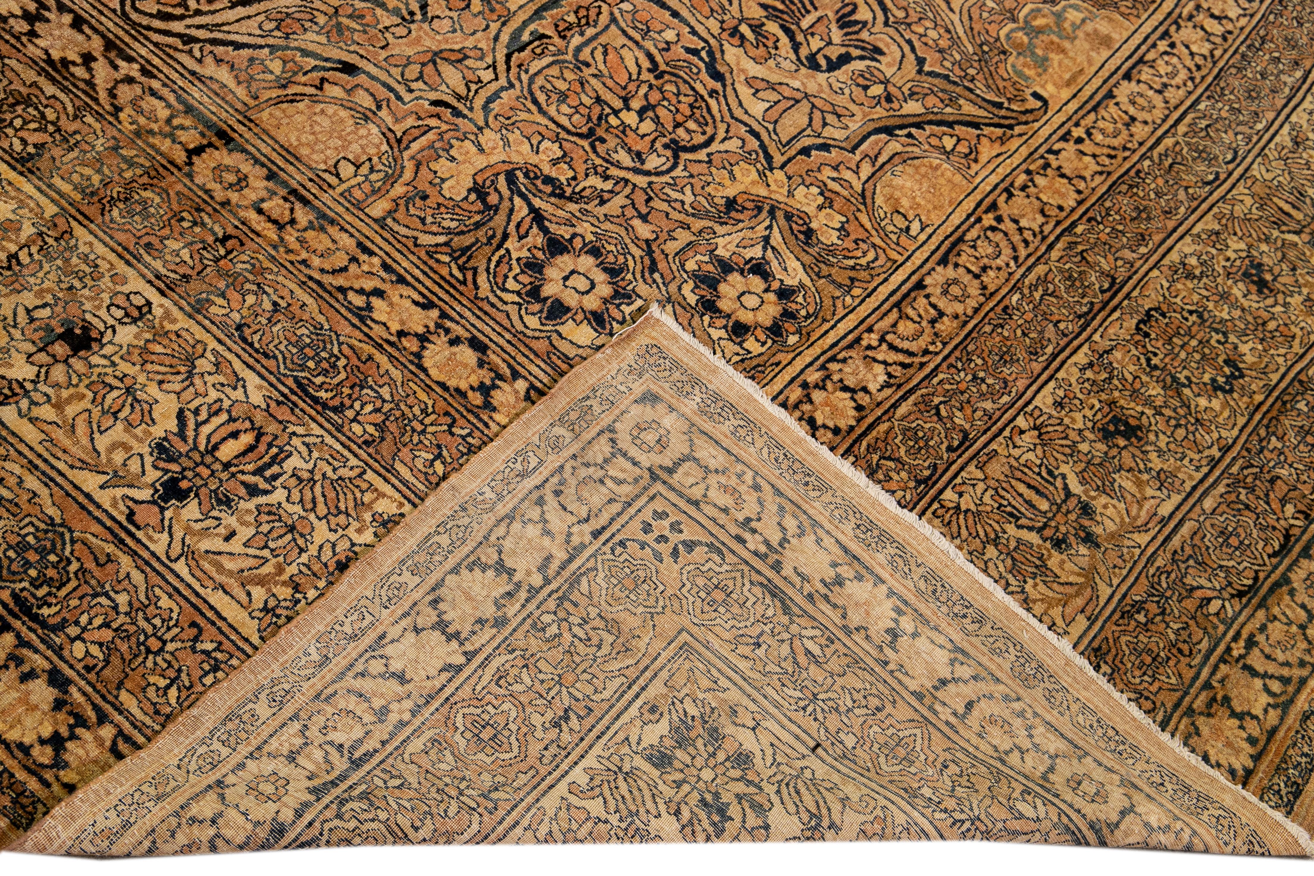 Magnifique tapis ancien noué à la main à Kerman avec un champ de verges d'or. Ce tapis persan présente des accents bleus, bruns et havane sur tout le magnifique motif floral botanique.

Ce tapis mesure 14' x 17'.
