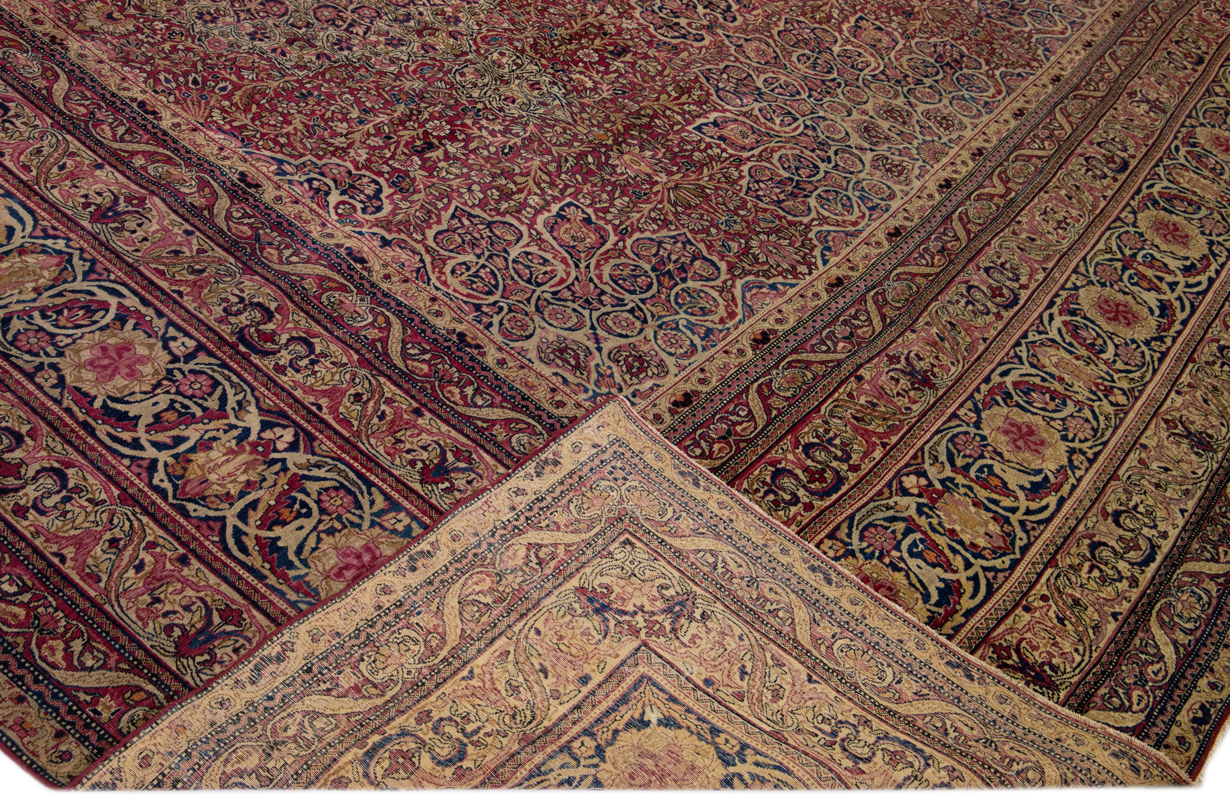 Beautiful antique Kerman hand-knotted wool rug with a red field. This Persian rug has multicolor accents in a gorgeous all-over rosette pattern design.

This rug measures: 14' x 23'5