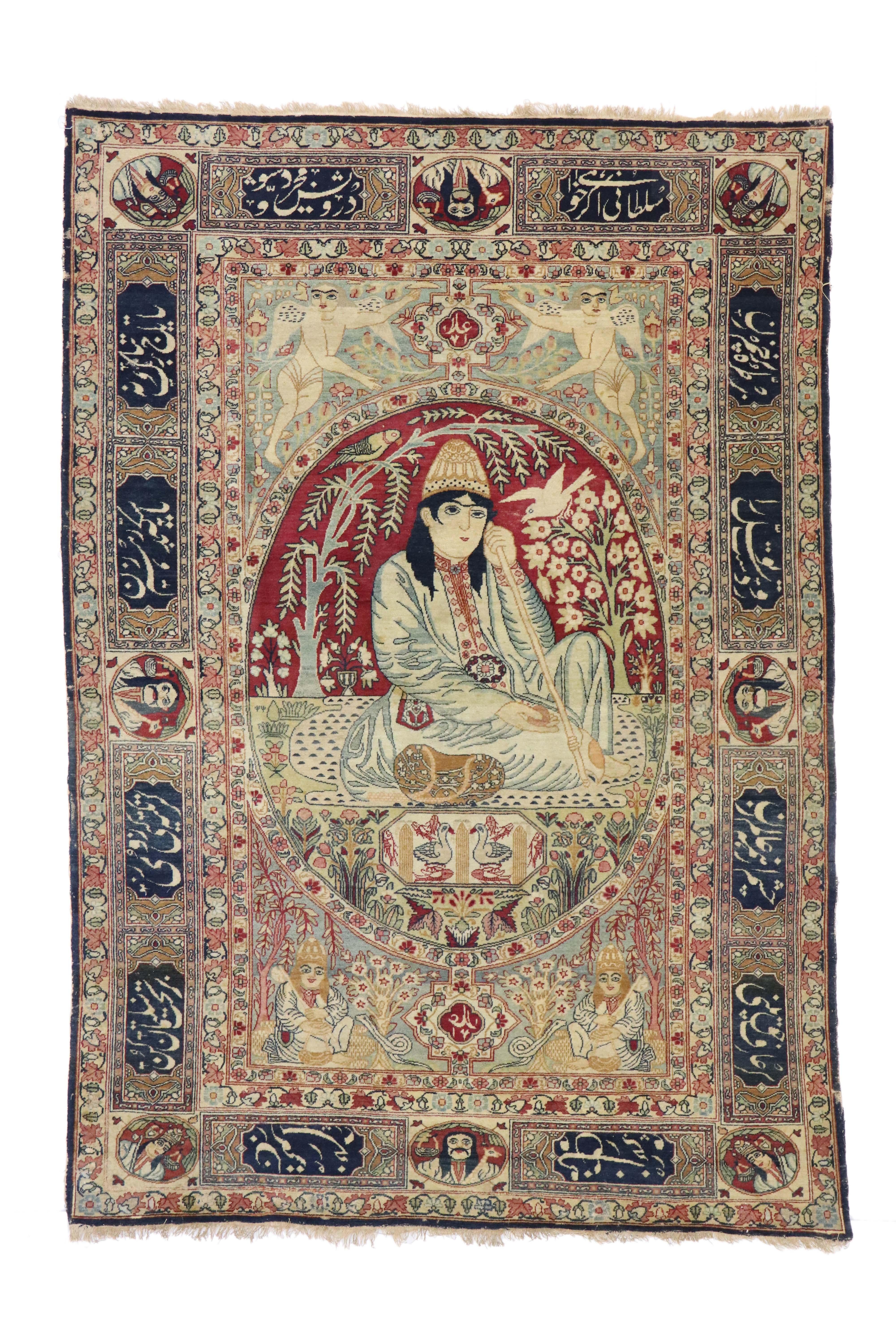 74336 Antique Persian Kerman Pictorial Rug, Dervish under Willow Tree Tapestry. Drawing inspiration from Nur Ali Shah, this antique Persian Kirman rug displays an expressive pictorial rug of a Dervish under a willow tree. In the center and
