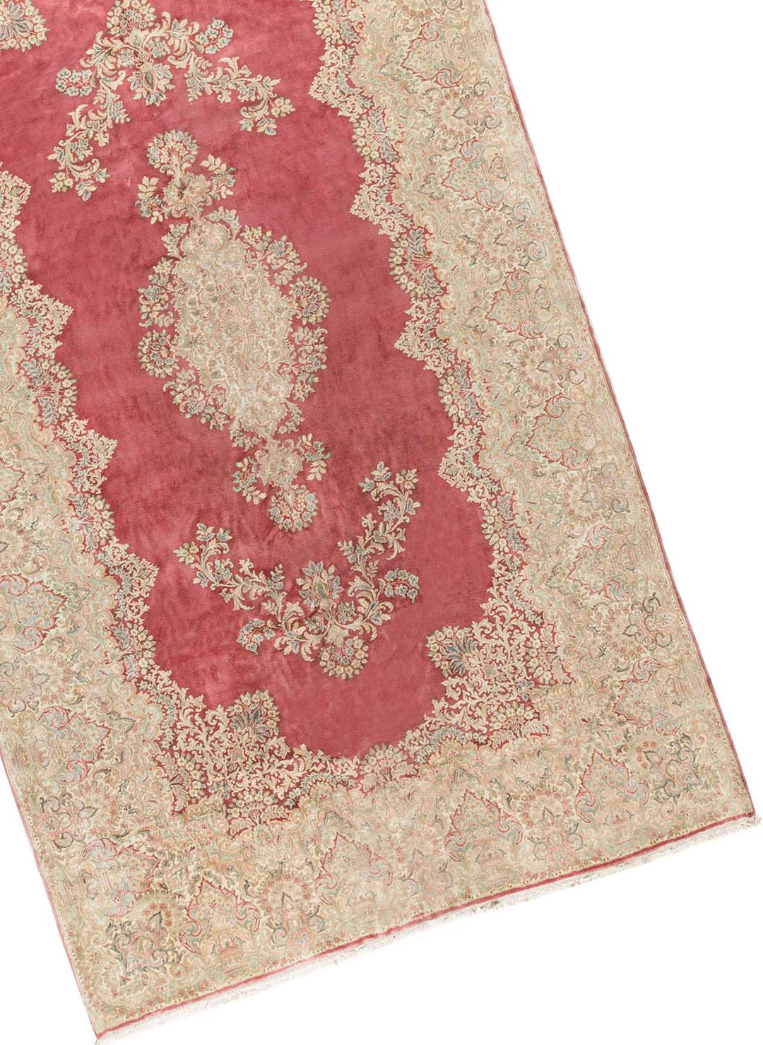 Antique Persian Kerman rug, circa 1890. This lovely rug has a soft rose ground with central floral filled medallions. The border repeats this floral theme with a profusion of beautiful and intricate designs enclosing the central field and almost
