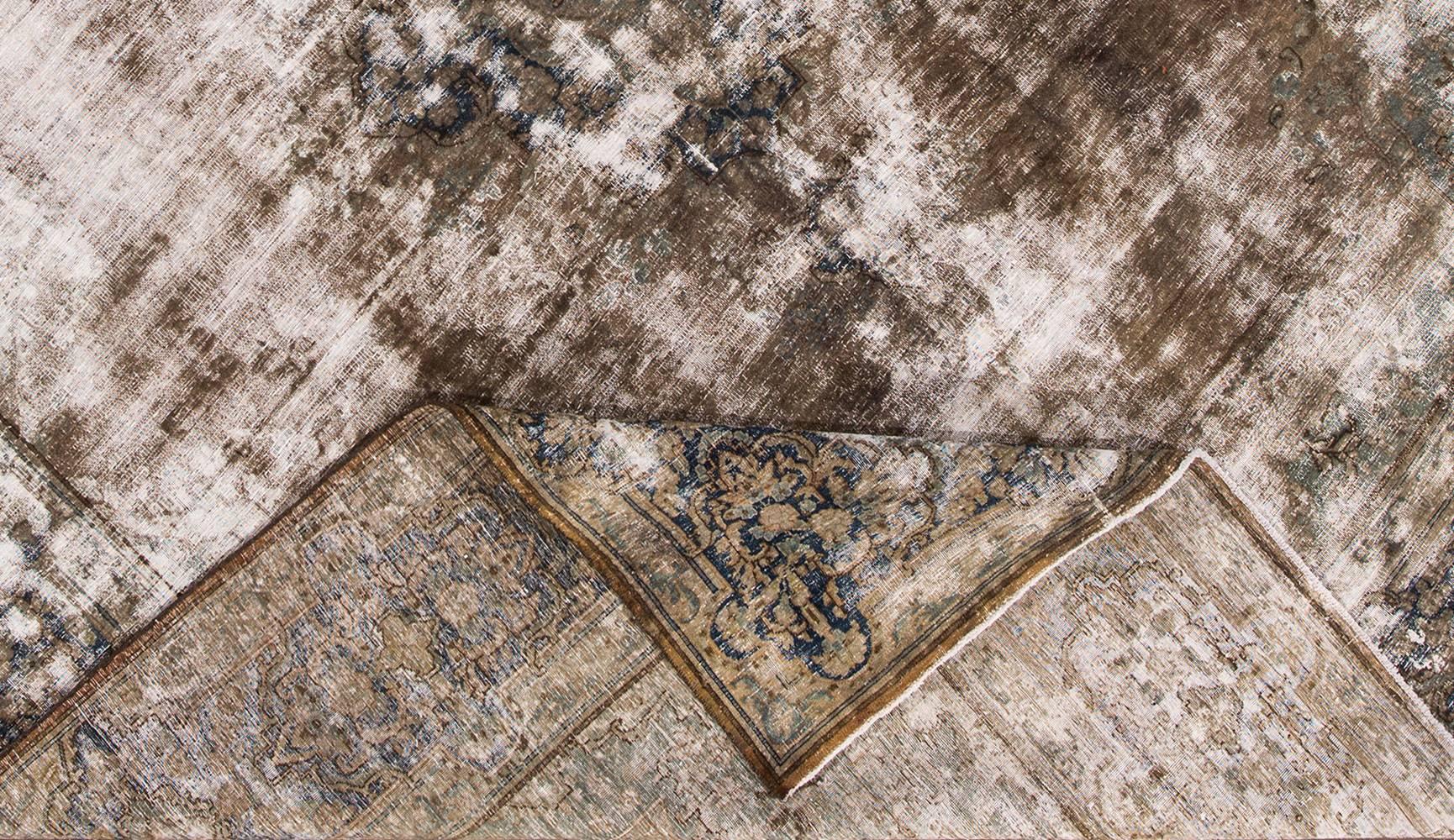 Antique hand-knotted Persian Kerman distressed rug with a subtle all-over motif on a gray field. This rug measures 10x13.03.
 