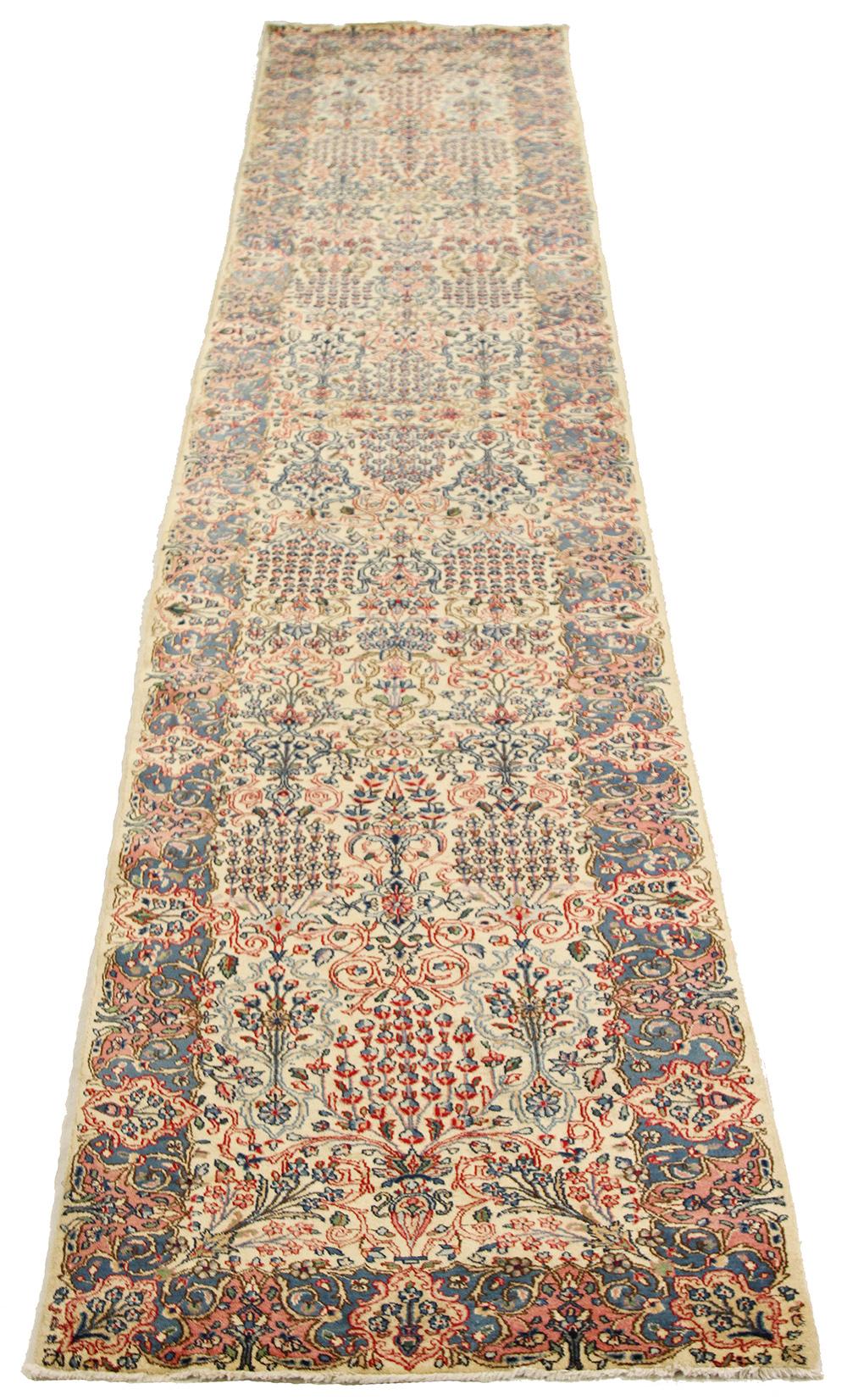 Antique Persian rug handwoven from the finest sheep’s wool and colored with all-natural vegetable dyes that are safe for humans and pets. It’s a traditional Kerman weaving featuring an elegant ensemble of floral designs in red and blue over an ivory