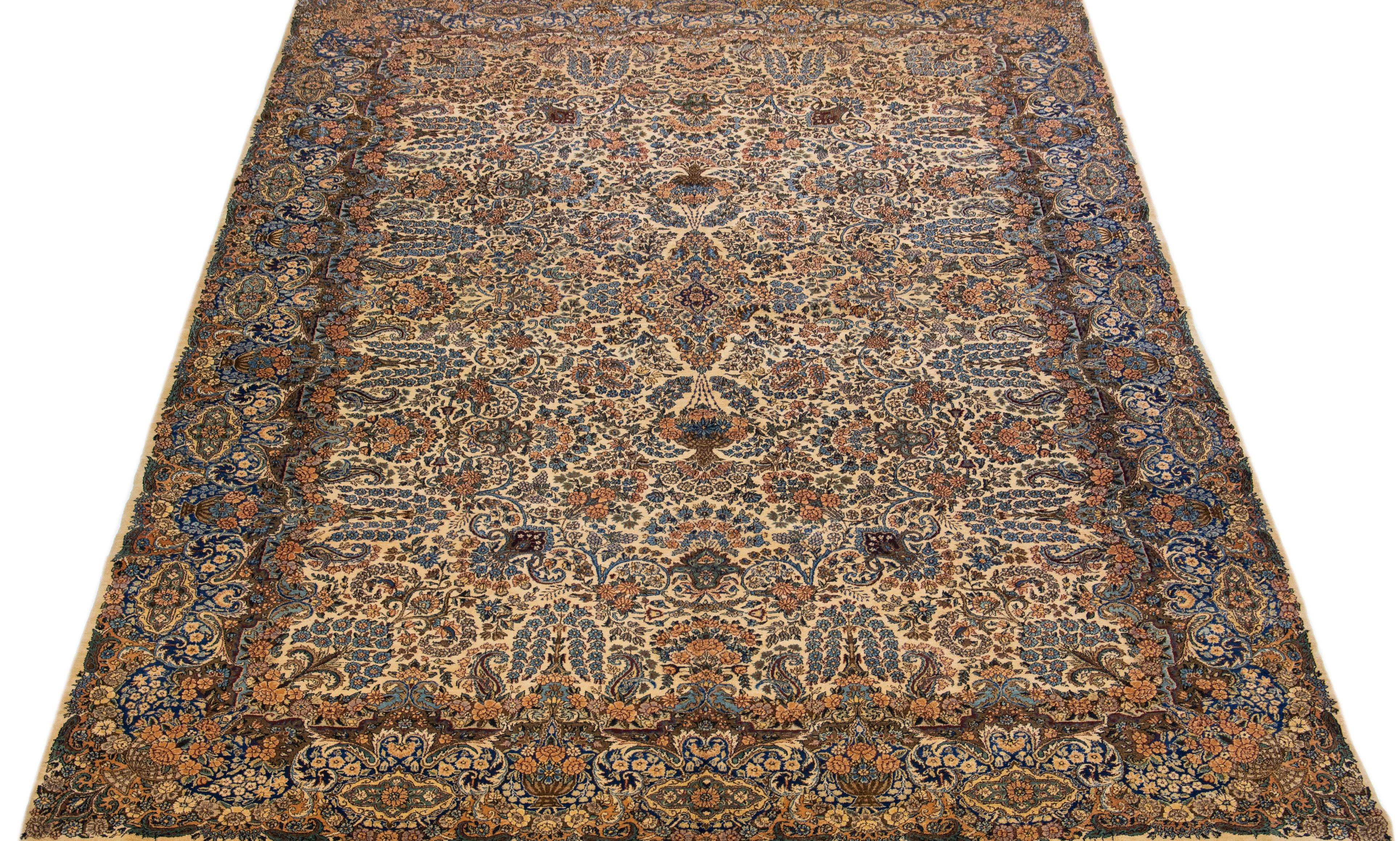 Beautiful antique Kerman hand-knotted wool rug with a beige color field. This Persian rug has multicolor accents in a gorgeous all-over medallion floral design.

This rug measures 9'8 x 13'9