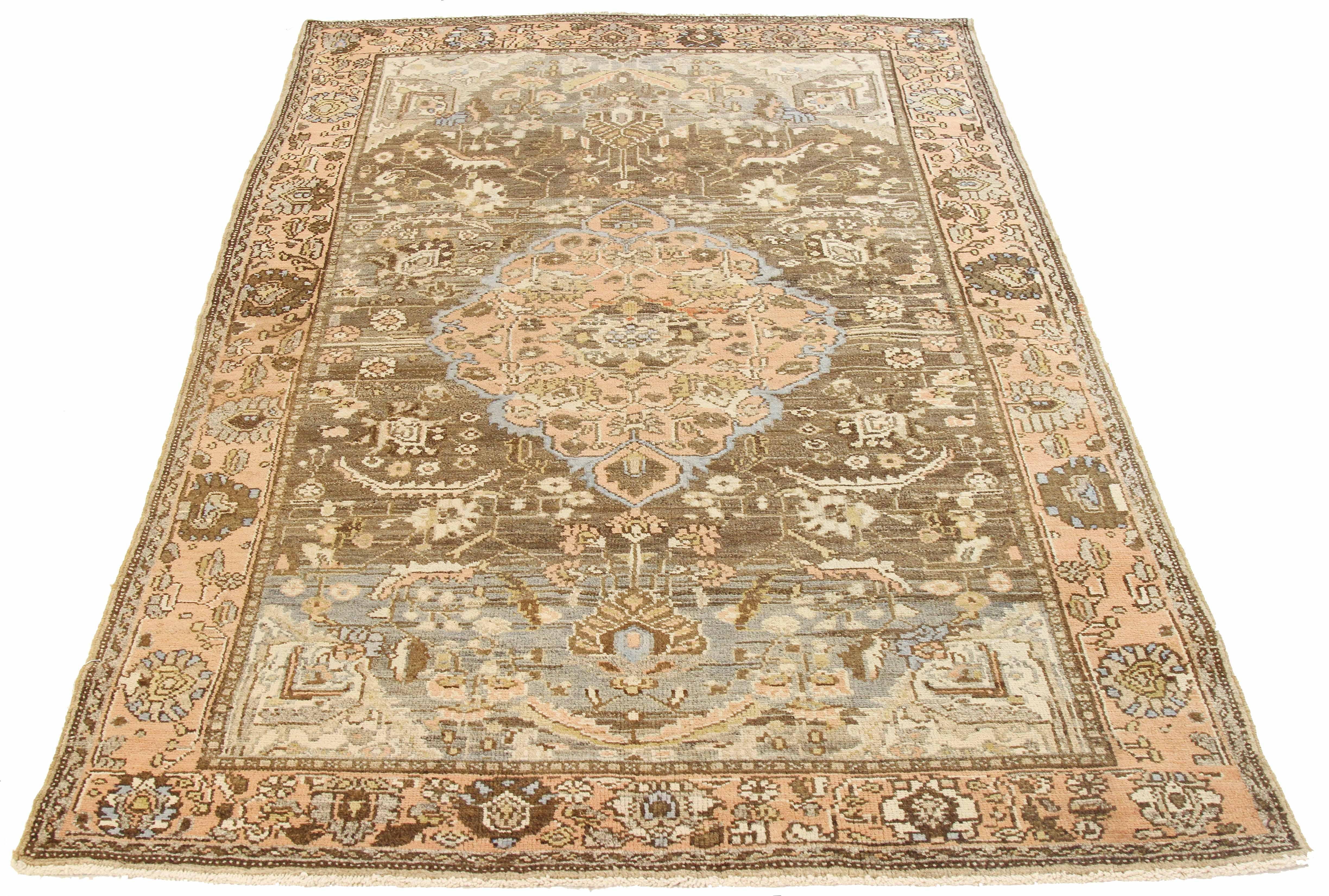 Antique Persian rug handwoven from the finest sheep’s wool and colored with all-natural vegetable dyes that are safe for humans and pets. It’s a traditional Khamseh design featuring a gorgeous brown and pink botanical field. It’s a stunning piece to