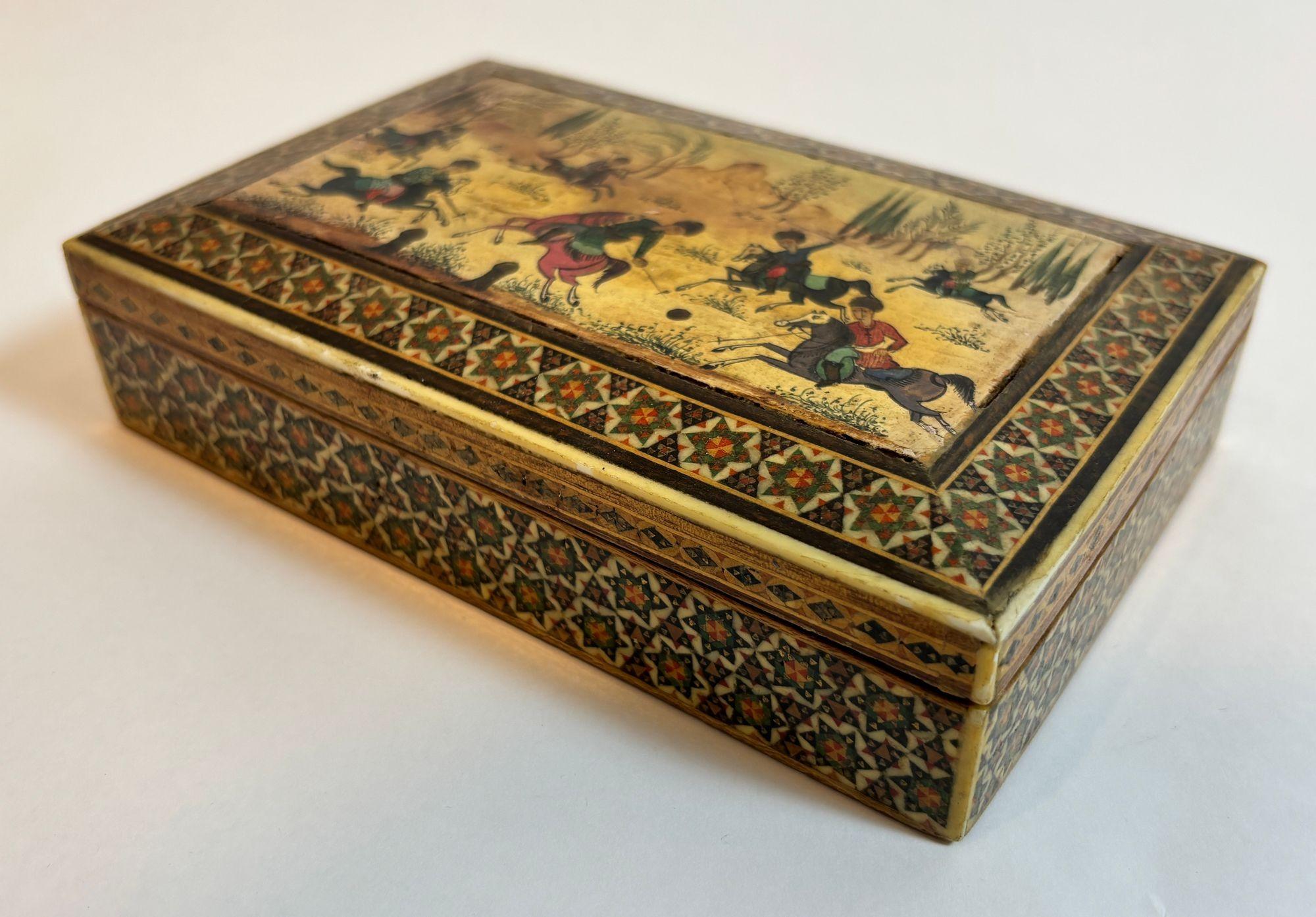 Ancienne boîte à bijoux persane à incrustation de micro-mosaïques Khatam avec scène de polo miniature, vers les années 1940
Cet exquis coffret à bibelots persan Khatam Kari est un rare exemple de marqueterie de micro-mosaïques, réalisée à la main