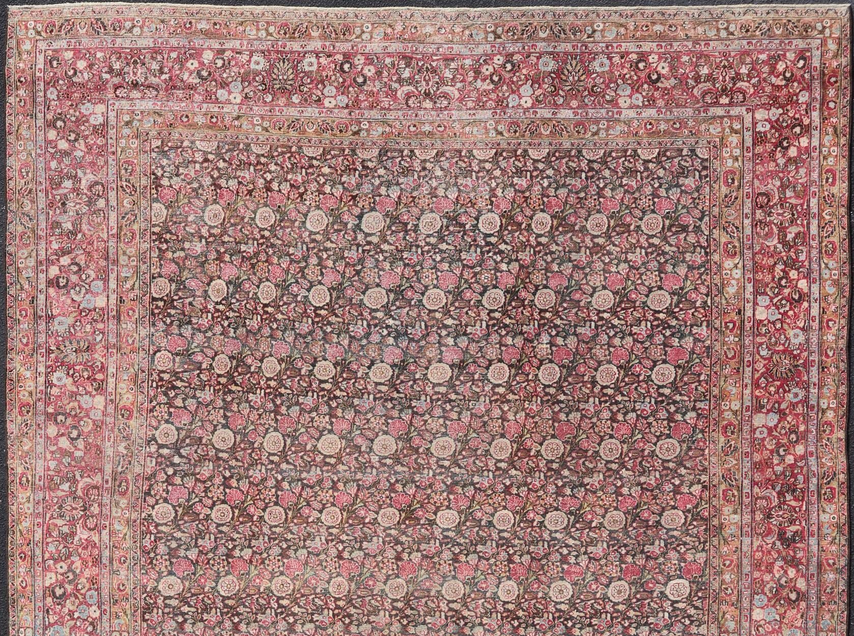 Large Antique Persian Khorasan rug with floral design in charcoal background and, red pink. Keivan Woven Arts / rug EMB-8502-178037, country of origin / type: Iran / Khorasan, circa 1920
Measures: 10'10 x 14'
This spectacular antique Persian