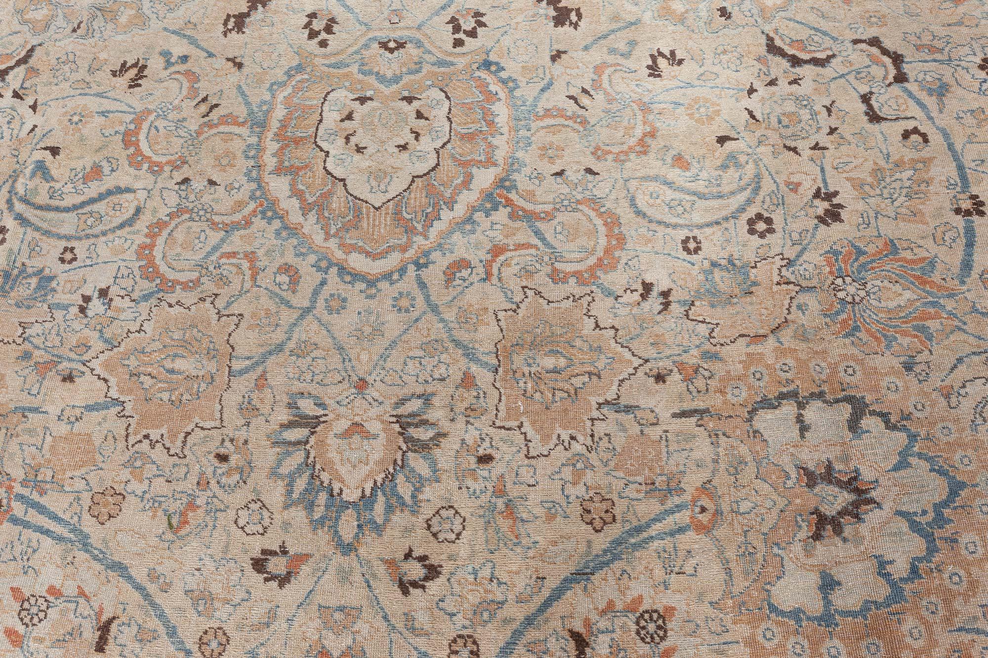 Antique Persian Khorassan handmade wool rug
This circa-1920 antique Persian Khorassan rug features an intricate all-over design of floral abstractions, arabesques, palmettes and curving vinery in shades of blue, brown and beige against a field of