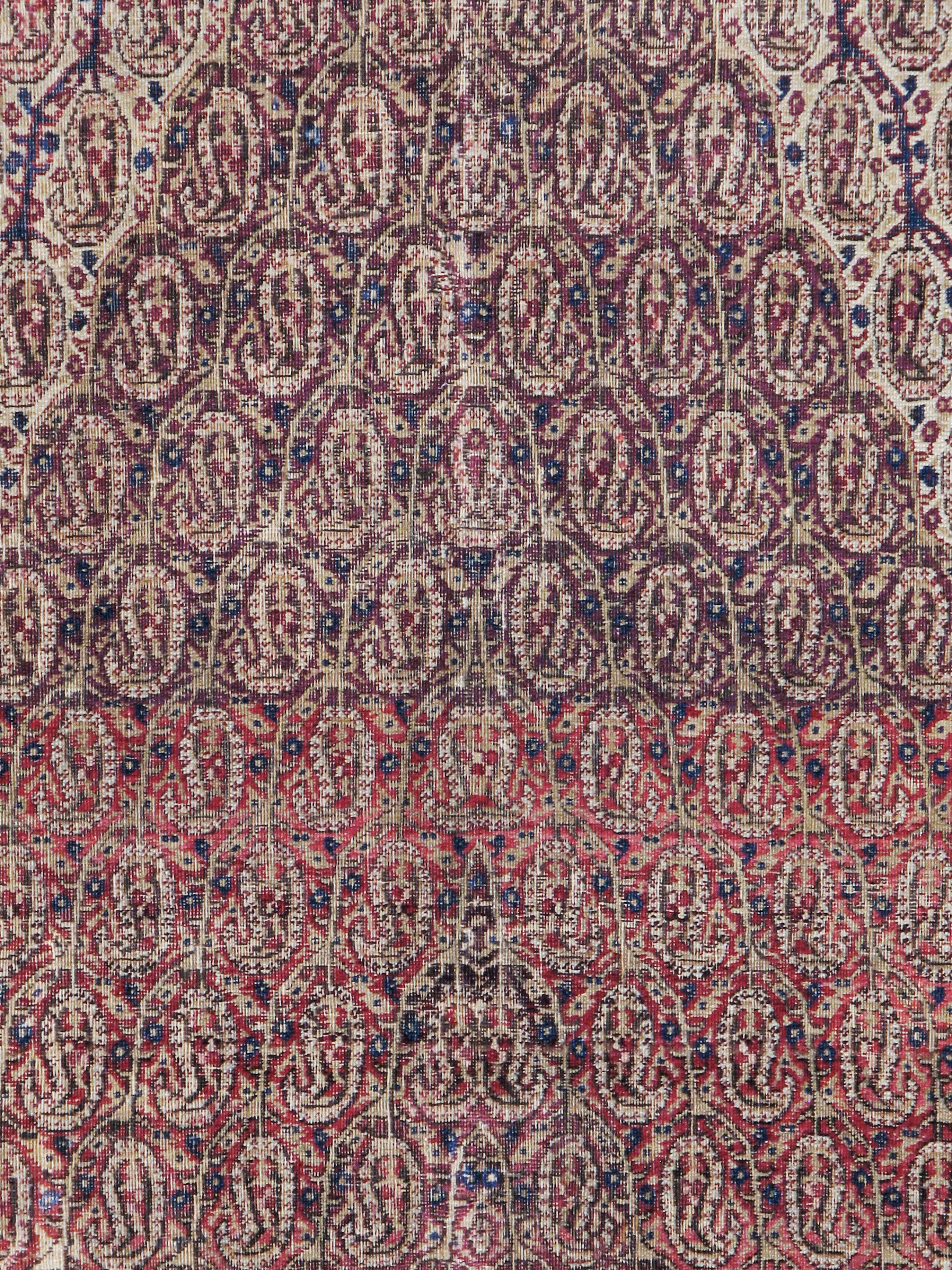 An antique Persian Khorassan carpet from the early 20th century. Botehs (paisleys) in the tall, end-to-end major brown hexagon. Botehs in the ivory field corners. Botehs in the main border. If you love the paisley design, you’ll positively adore
