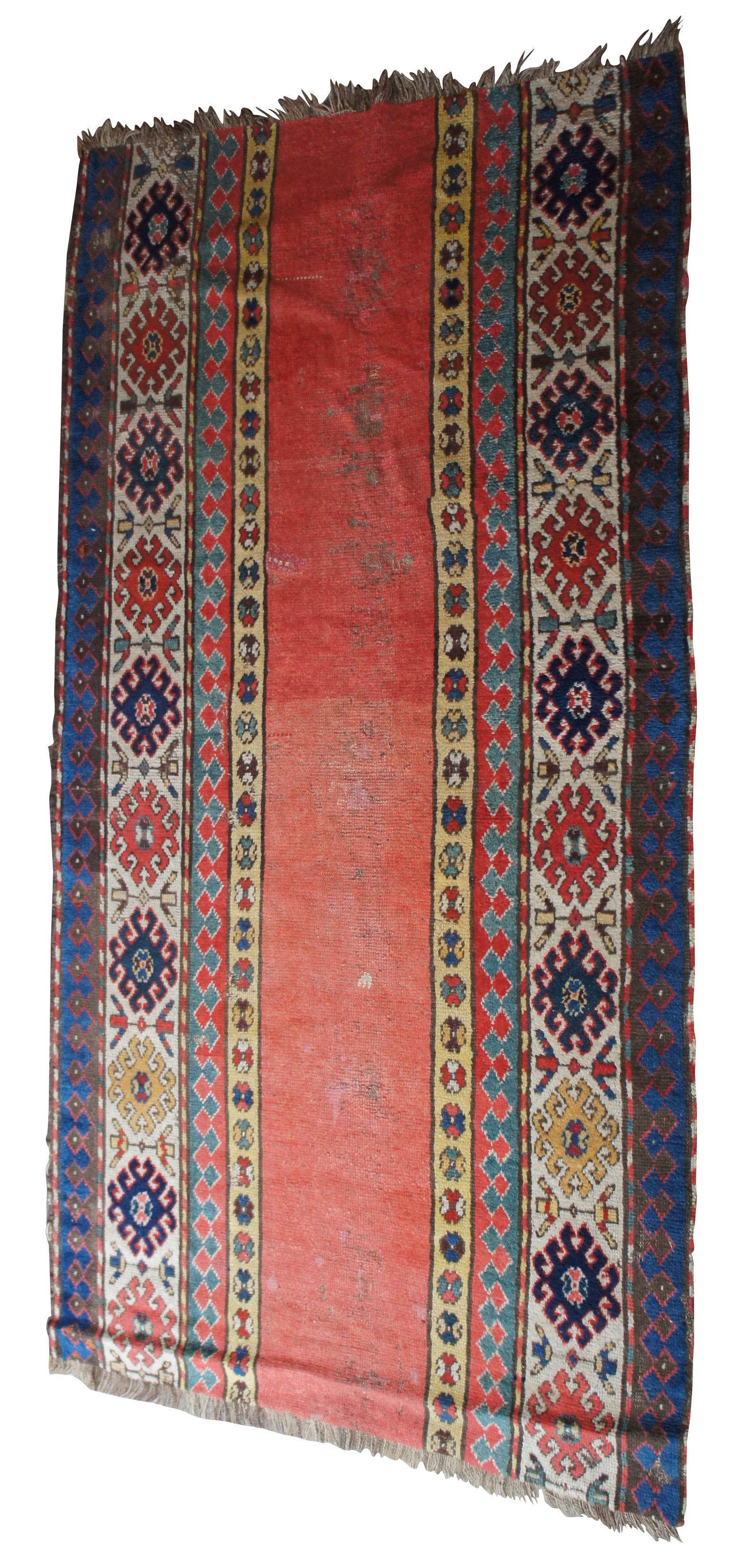 Antique Persian rug runner featuring long floral and geometric designs. Reds, greens, blues, brown, yellow, tan, pink. Measure: 73