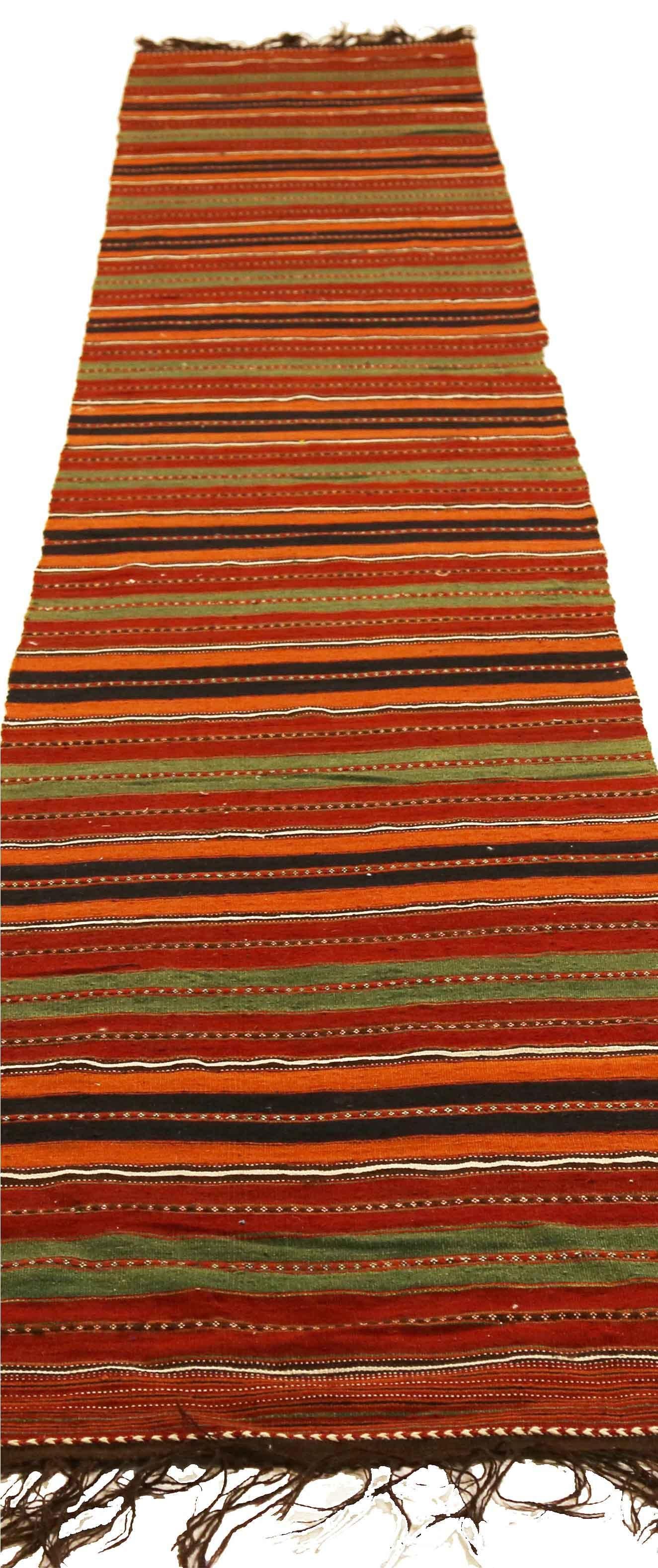 Antique handmade Persian runner rug from high quality sheep’s wool and colored with eco-friendly vegetable dyes that are proven safe for humans and pets alike. It’s a Classic Kilim design showcasing red and orange stripes on a regal brown field.