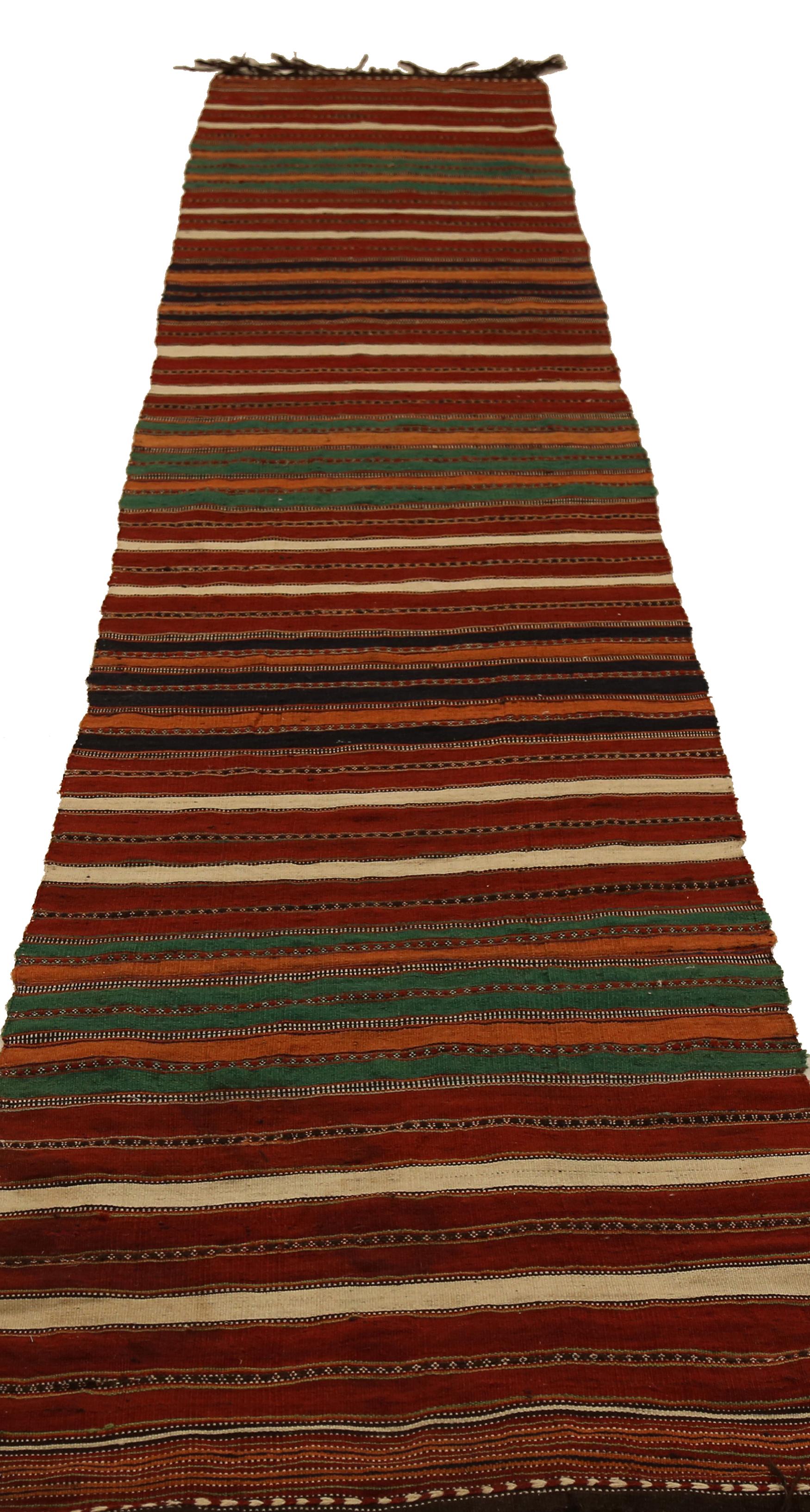 Antique handmade Persian runner rug from high quality sheep’s wool and colored with eco-friendly vegetable dyes that are proven safe for humans and pets alike. It’s a Classic Kilim design showcasing red and green stripes on a regal red/brown field.
