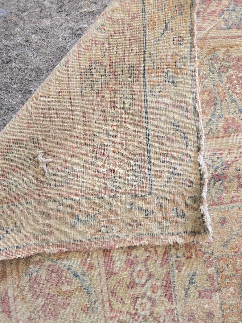 Ajoutez une touche d'élégance intemporelle à votre espace avec cet ancien tapis persan Kirman, un exemple époustouflant de l'art persan noué à la main. Fabriqué à Kirman, en Perse, ce tapis en laine de 9,4 x 14 est orné d'un médaillon central