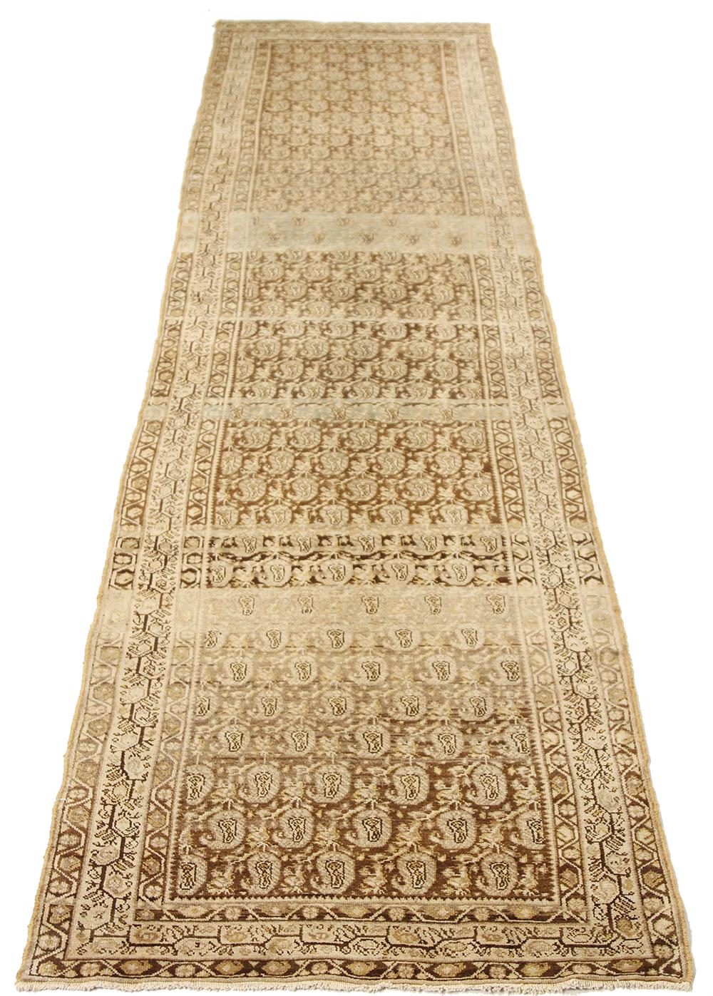 Antique Persian runner rug handwoven from the finest sheep’s wool and colored with all-natural vegetable dyes that are safe for humans and pets. It’s a traditional Koliai design featuring details in ivory and brown. It’s a beautiful piece for