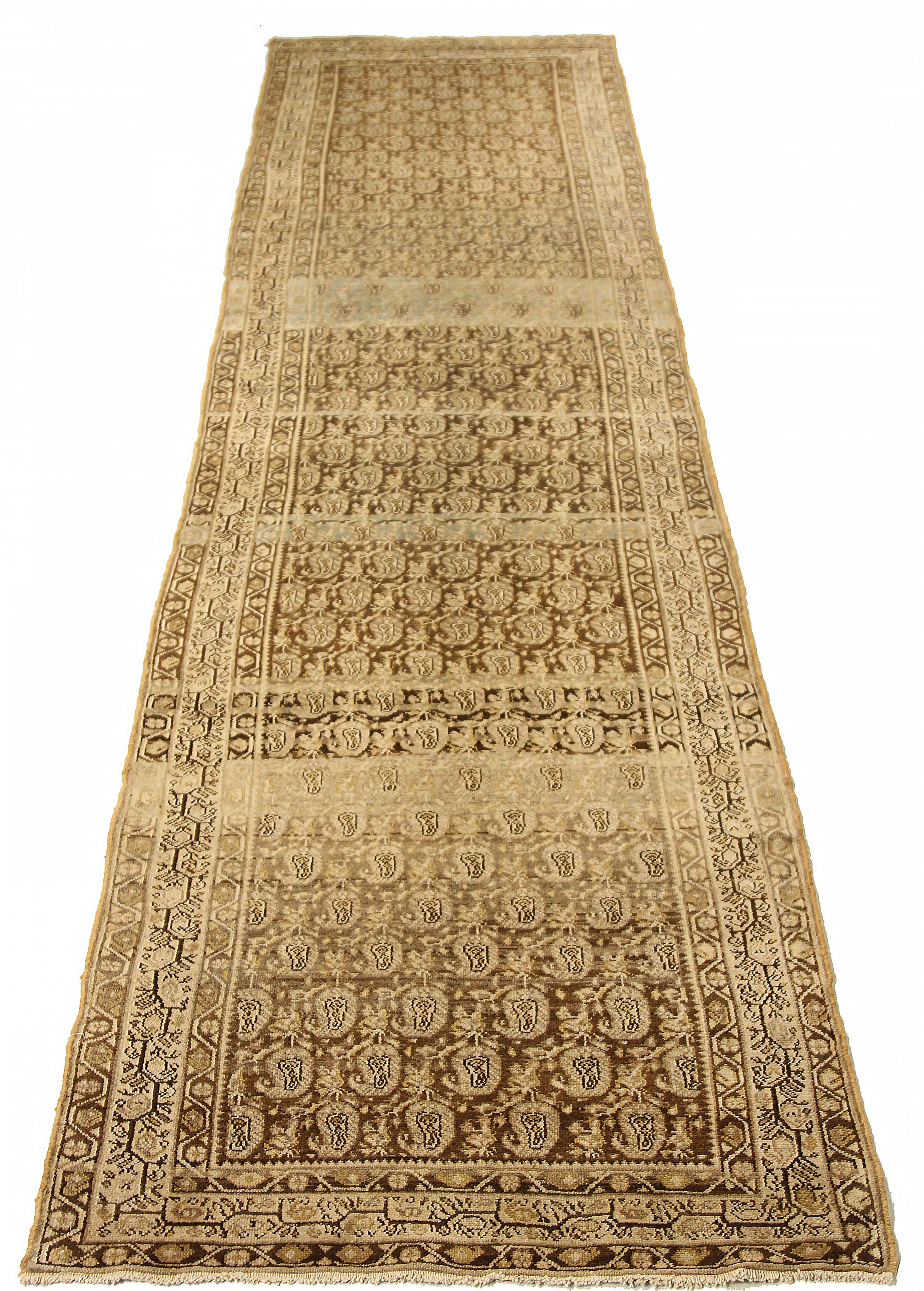 Antique Persian runner rug handwoven from the finest sheep’s wool and colored with all-natural vegetable dyes that are safe for humans and pets. It’s a traditional Koliai design featuring tribal and floral details on a beige field. It’s a beautiful