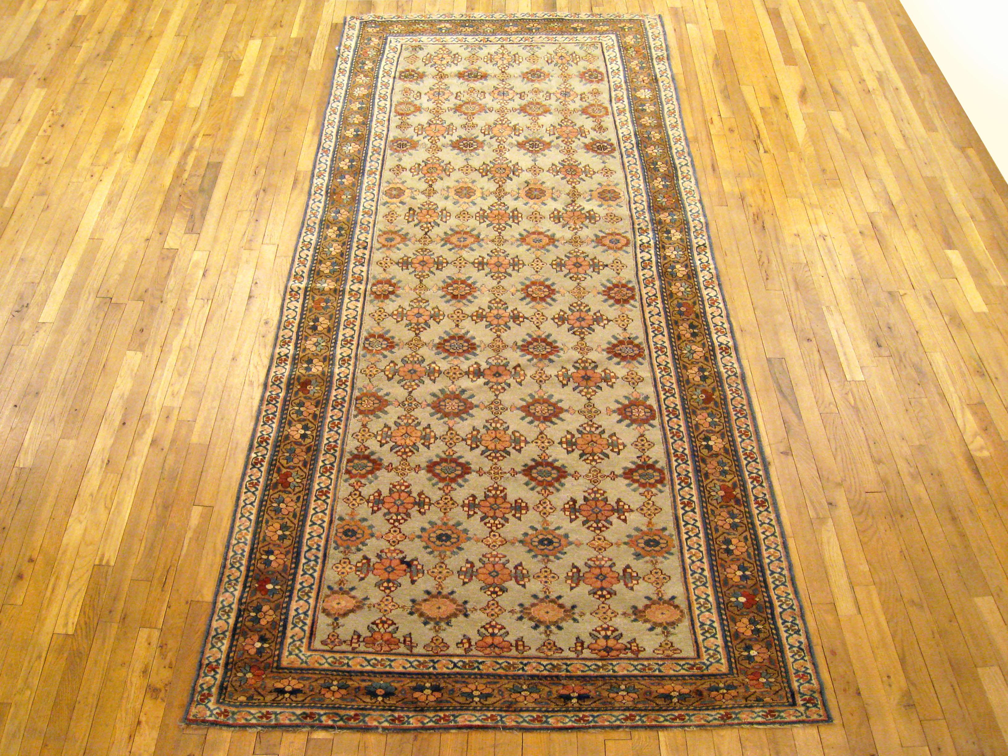 Antique Persian Kurd rug, Gallery size, circa 1920

A one-of-a-kind vintage Persian Kurd Oriental Carpet, hand-knotted with soft wool pile. This lovely hand-knotted rug features rosettes design allover the blue primary field, with a light brown
