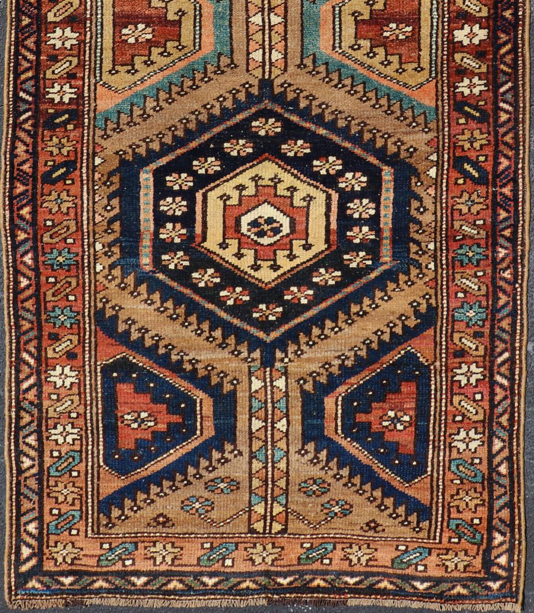 Medallion design on camel field, with dark blue medallions, green, red, blue , rug EMB-8546-178695, country of origin / type: Iran / Hamedan, circa 1910

This antique Kurdish (circa early 20th century) short runner features a unique blend of