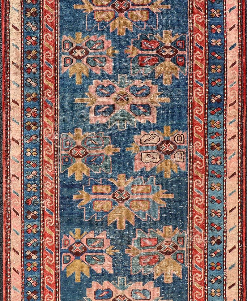 Measures: 2'11 x 7'3 

This antique Kurdish runner displays great contrast between the bold blue and red against softened coral tones in the outer border. A similar color palette in the field's pattern utilizes light pink, yellow, light teal and
