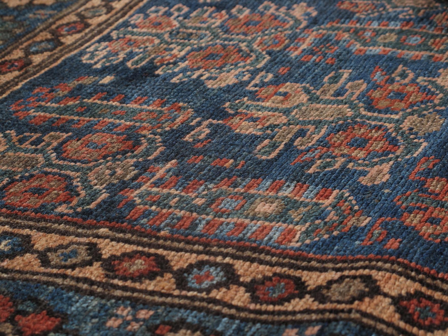 This antique Persian Kuridsh rug is skillfully sourced by N A S I R I through extensive travel, passion, and research. Kurdish rugs are named after a major rug weaving village in central west Iran. The village was known for producing extremely fine