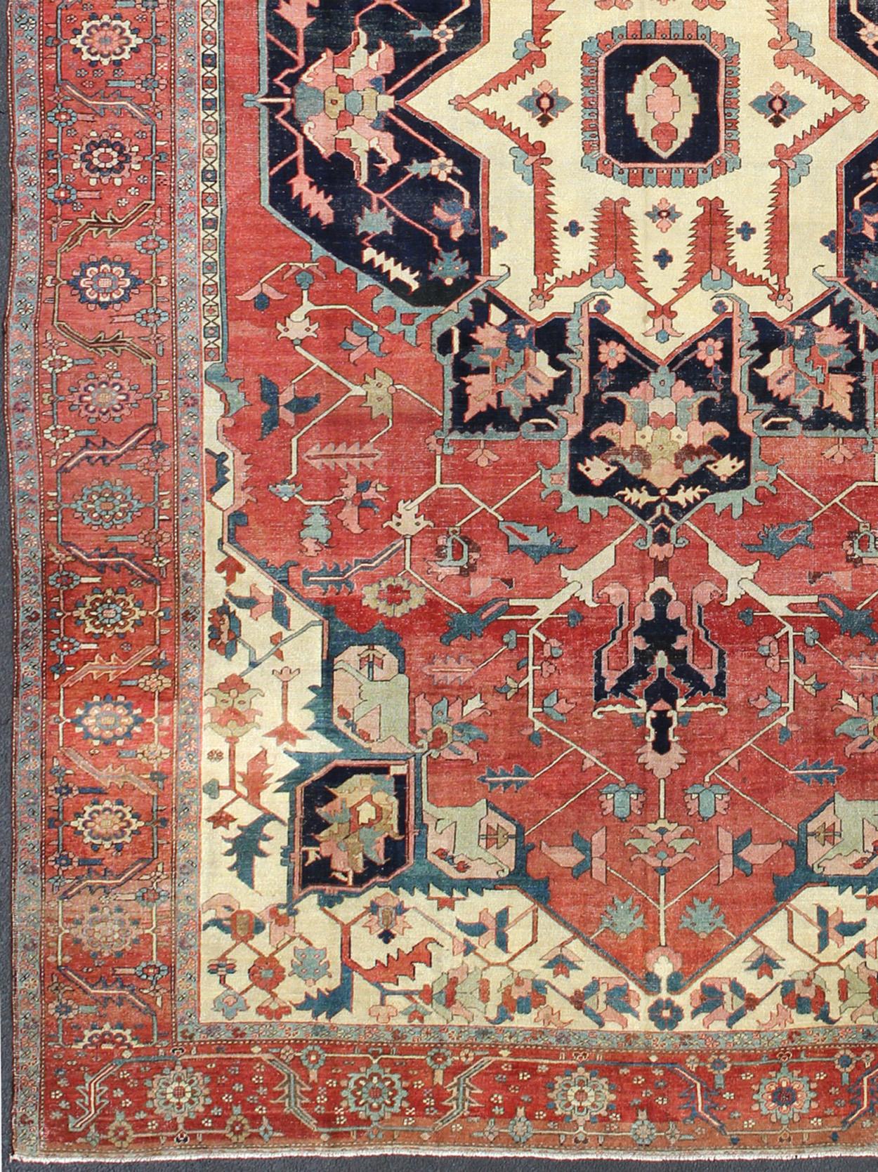 Large Antique Persian Serapi Rug in Faded Red, Teal, Navy Blue, and Ivory with Large Geometric Medallion, antique Persian Serapi rug / N15-1203, country of origin / type: Iran / Serapi

Serapi rugs are known as the finest rugs produced in the Heriz