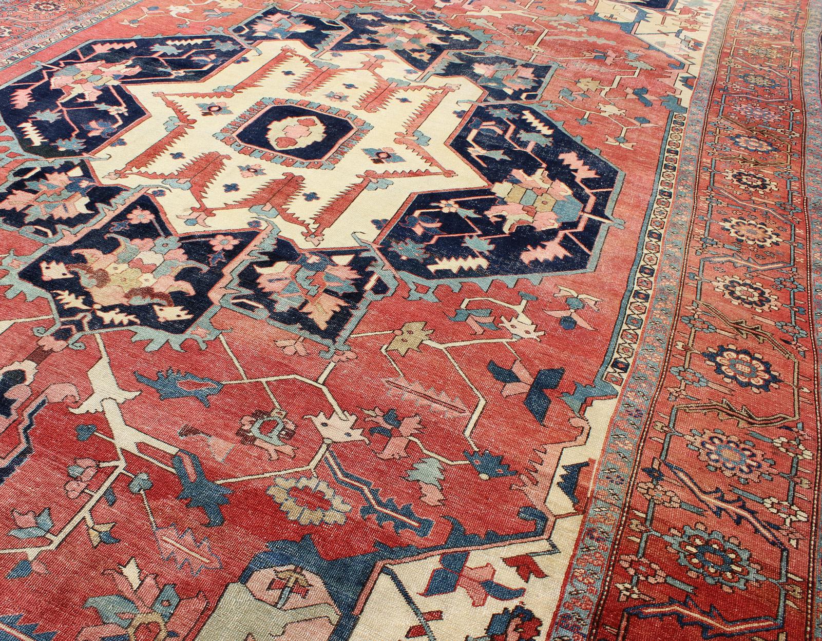 Wool Large Antique Persian Serapi Rug in Faded Red, Teal, Navy Blue, and Ivory For Sale