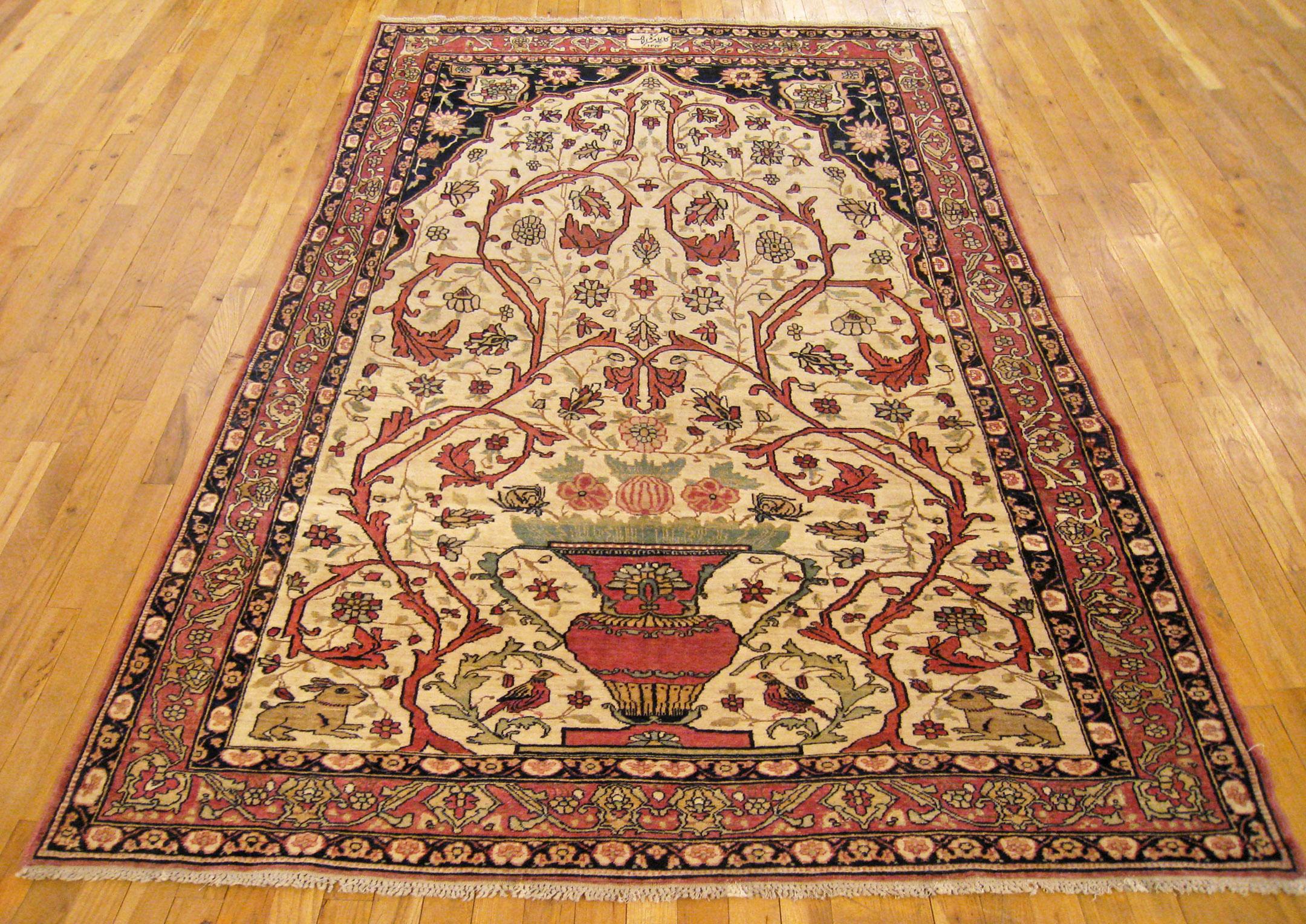 An antique Persian Lavar Kerman oriental rug, size 8'4 x 5'0, circa 1906. This antique hand-knotted wool rug features a vase design in the finely detailed ivory central field, with a prayer arch at one end, and a weaver's mark in the upper border.