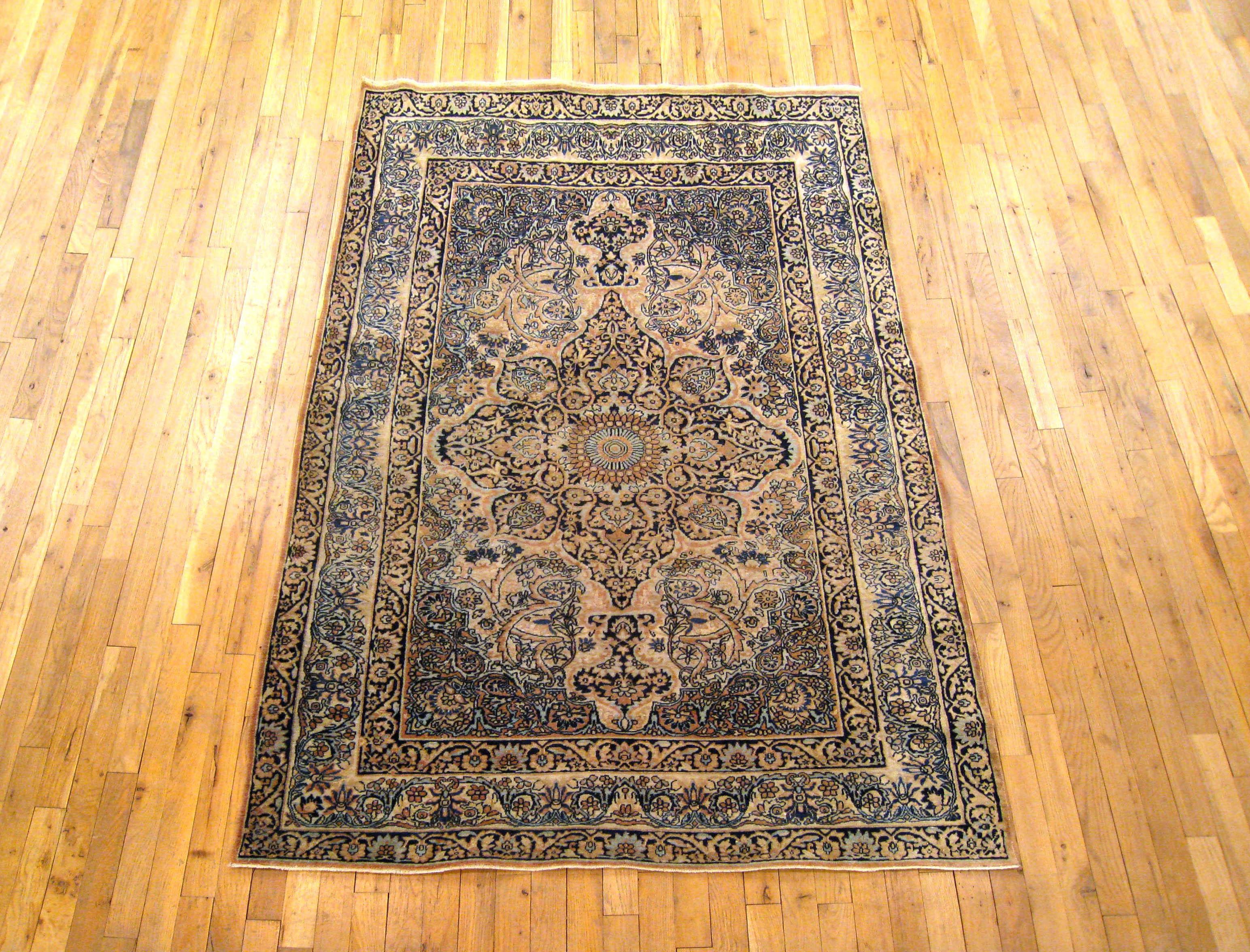 An antique Persian Lavar rug, size 6'5 H x 4'4 W, circa 1900. This fine hand-knotted oriental rug features a beautiful central medallion, encompassed by floral reserves in each corner. The primary border and guard borders reiterate and expand upon