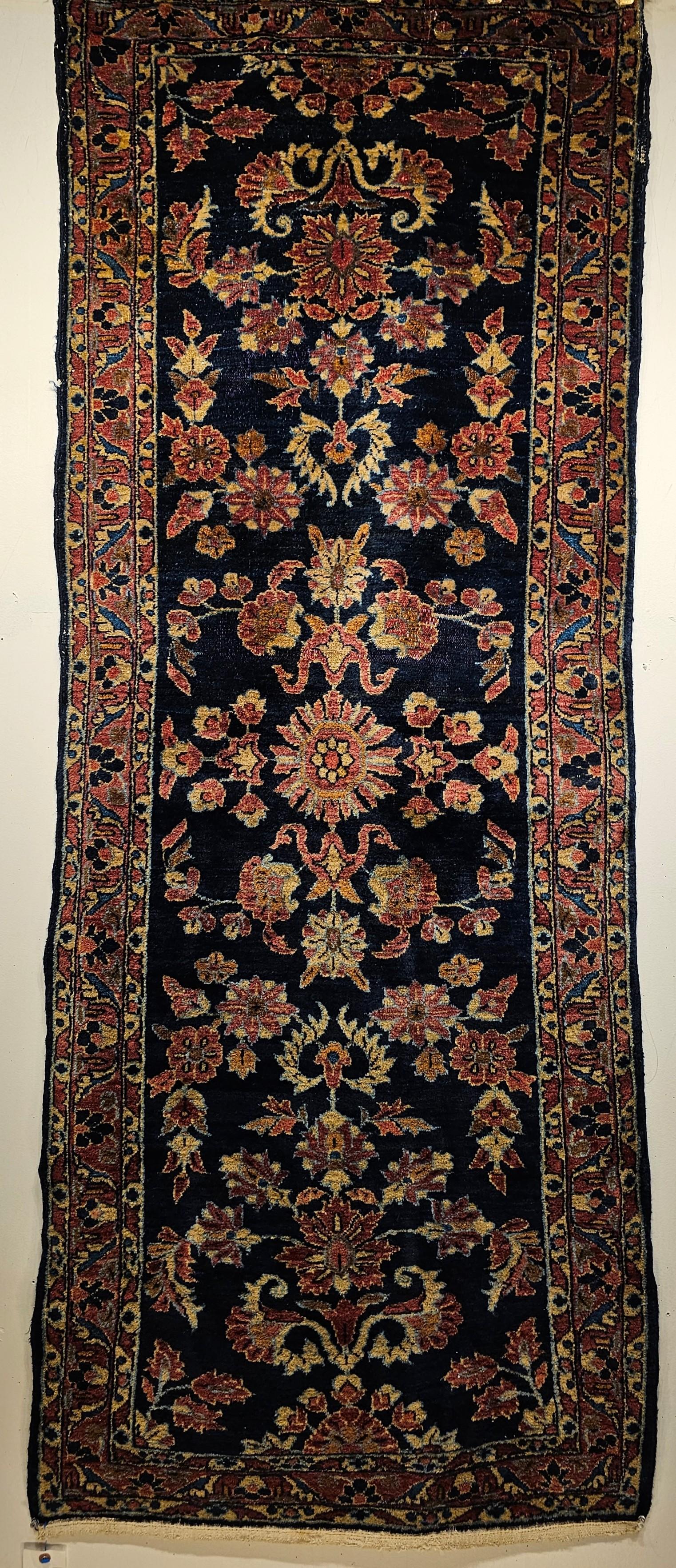 An early 1900s Persian Lilian Runner in an Allover Floral Design in abrash navy blue.  The Lilian runner has an all-over floral pattern set in an abrash navy blue field.  The flowers have beautiful shades of green, blue, red, and pink bringing