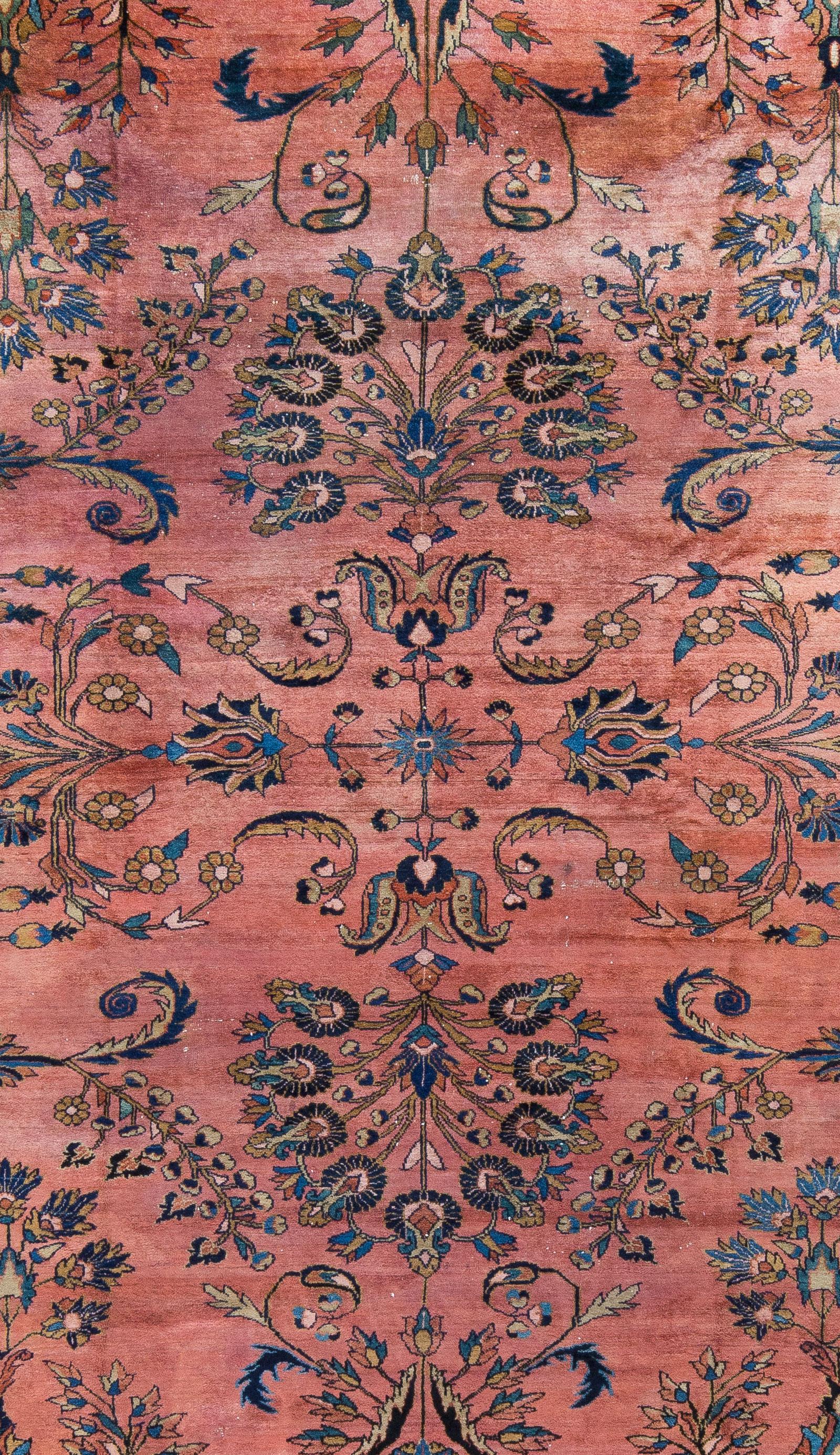 Un Lilihan centenario con una lana morbida e lucente. Un disegno aperto in grano, blu navy e fiordaliso su un campo di salmone intenso. Lo spazio negativo rende questo tappeto leggero e piacevole. Tinta naturale. 
